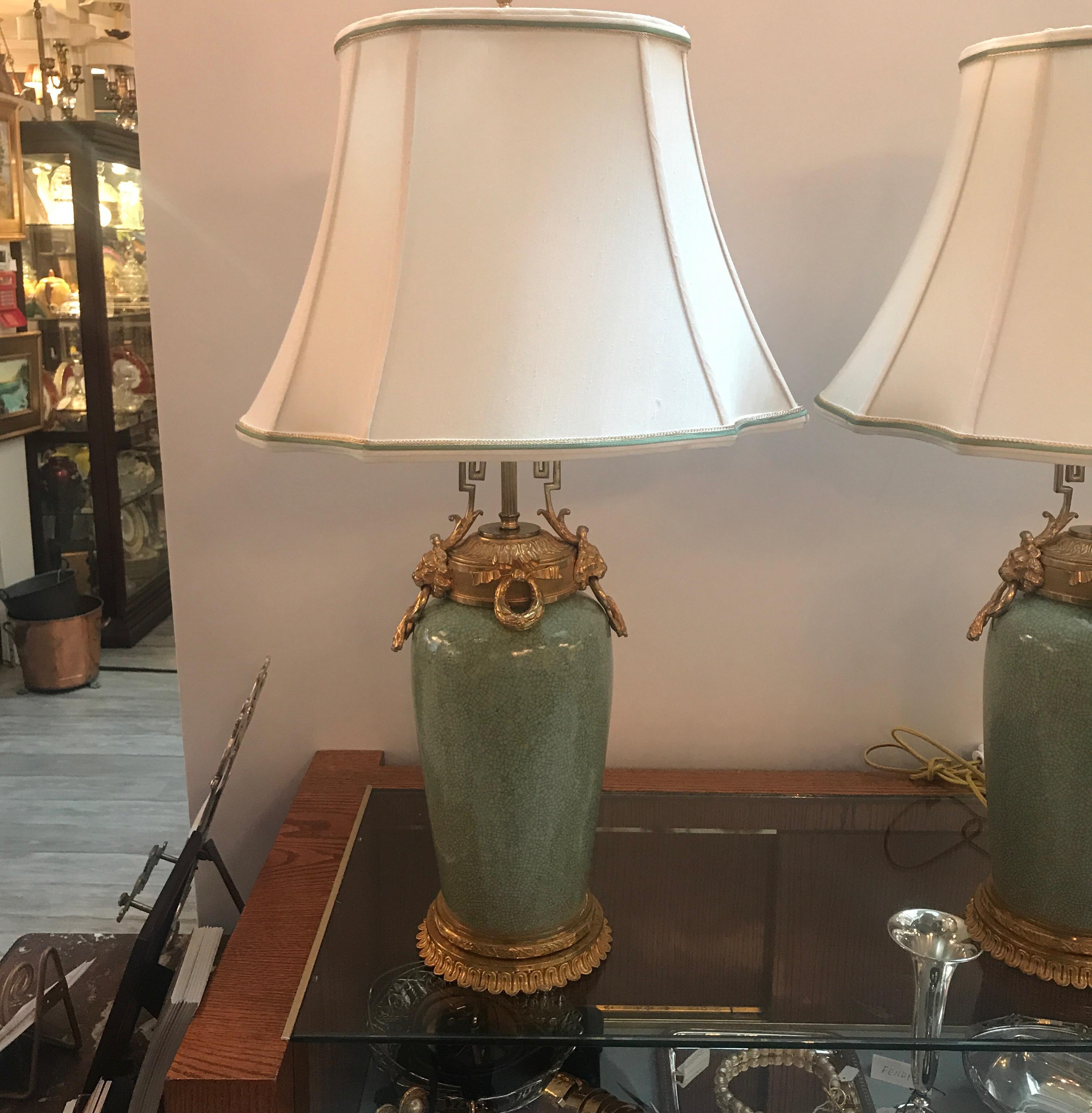 Elegant pair of Chinese porcelain celedon vases now as lamps with later French gilt bronze mounts. The porcelain in celedon green with a light crackle finish with gilt tops and bases. The shades are for photographic purposes only and not included