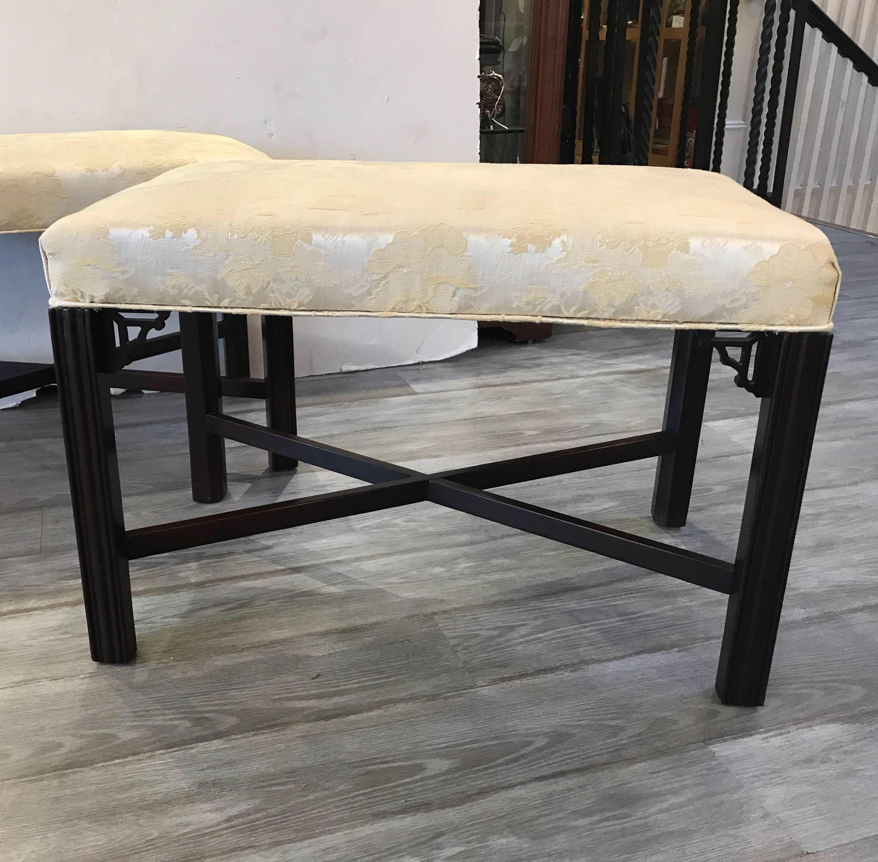 A pair of newly upholstered Chinese Chippendale mahogany benches. The classic straight leg with corner detail and X-stretcher. The fabric is a soft yellow chinoiserie damask.