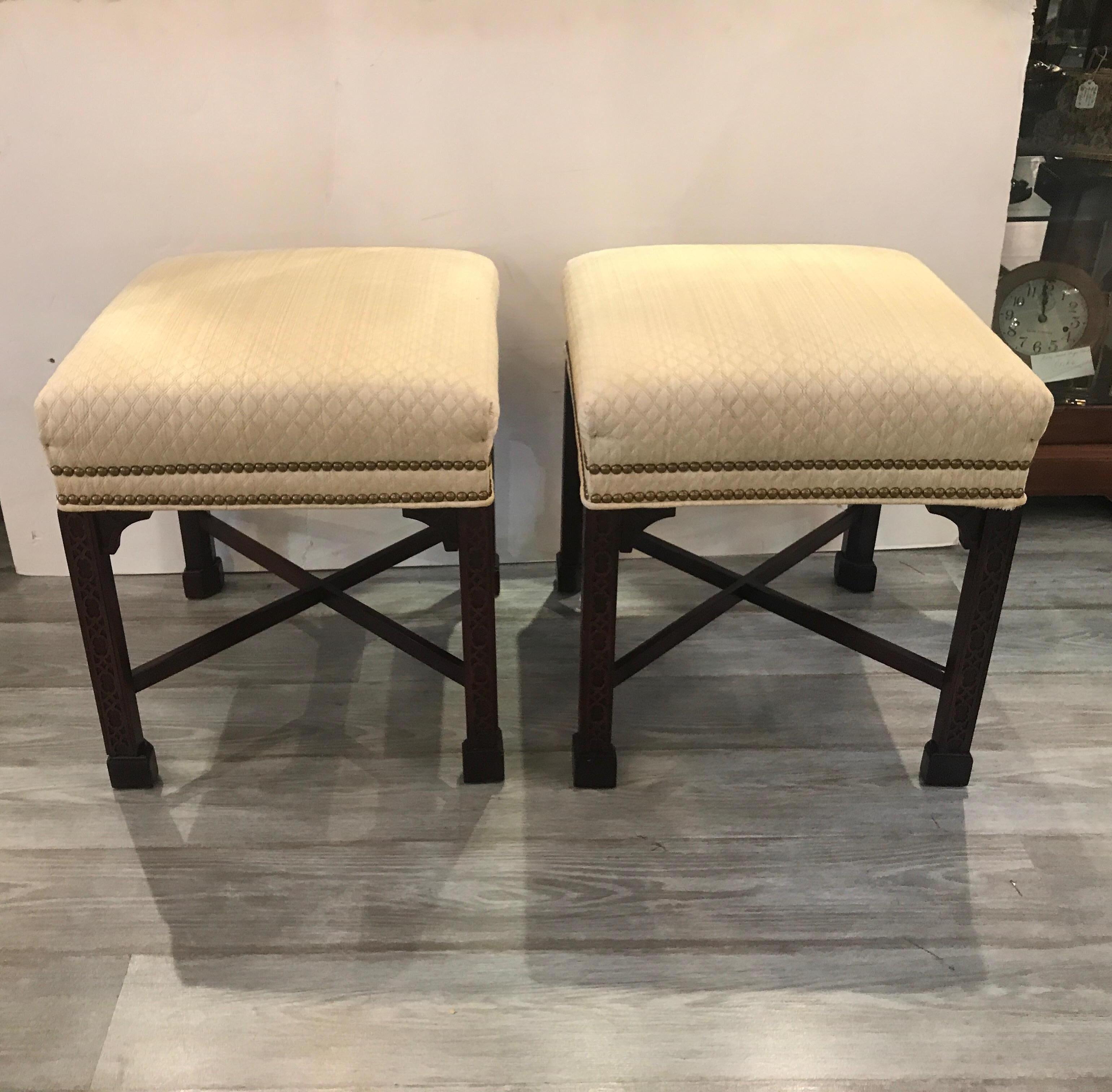 Elegant pair of Chinese Chippendale mahogany square benches sold by W. & J. Sloane NYC. The Classic straight legs with trellis design and corner brackets covered is a neutral Matisse fabric. The fabric has some light staining on one corner but we