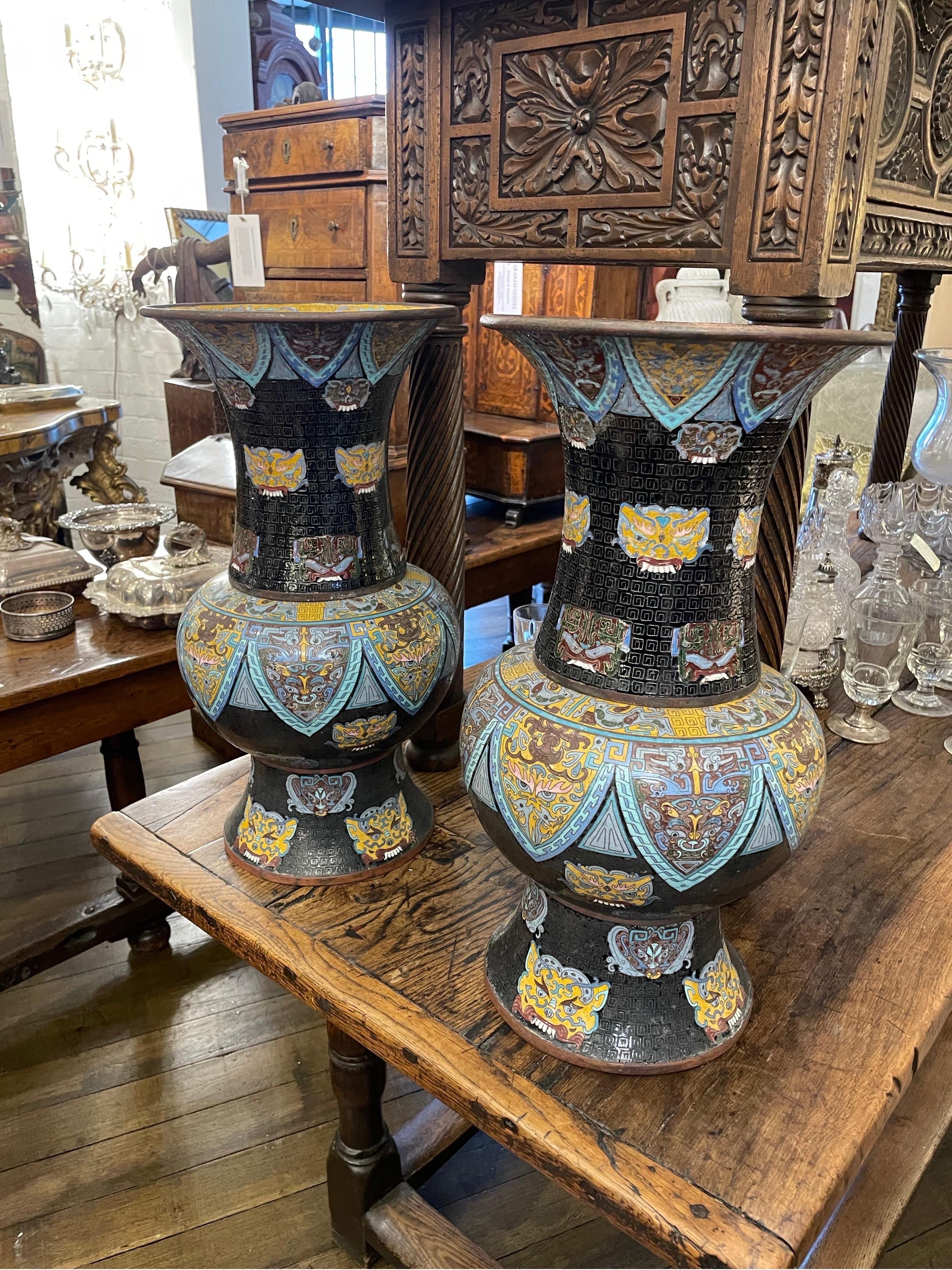 A Pair of Chinese Cloisonne Baluster Vases, Late 19th Century

Each of baluster form with an everted lip and trumpet neck descending to broad shoulders and a flared base, the enamelwork with a black background, various yellow and polychrome taotie