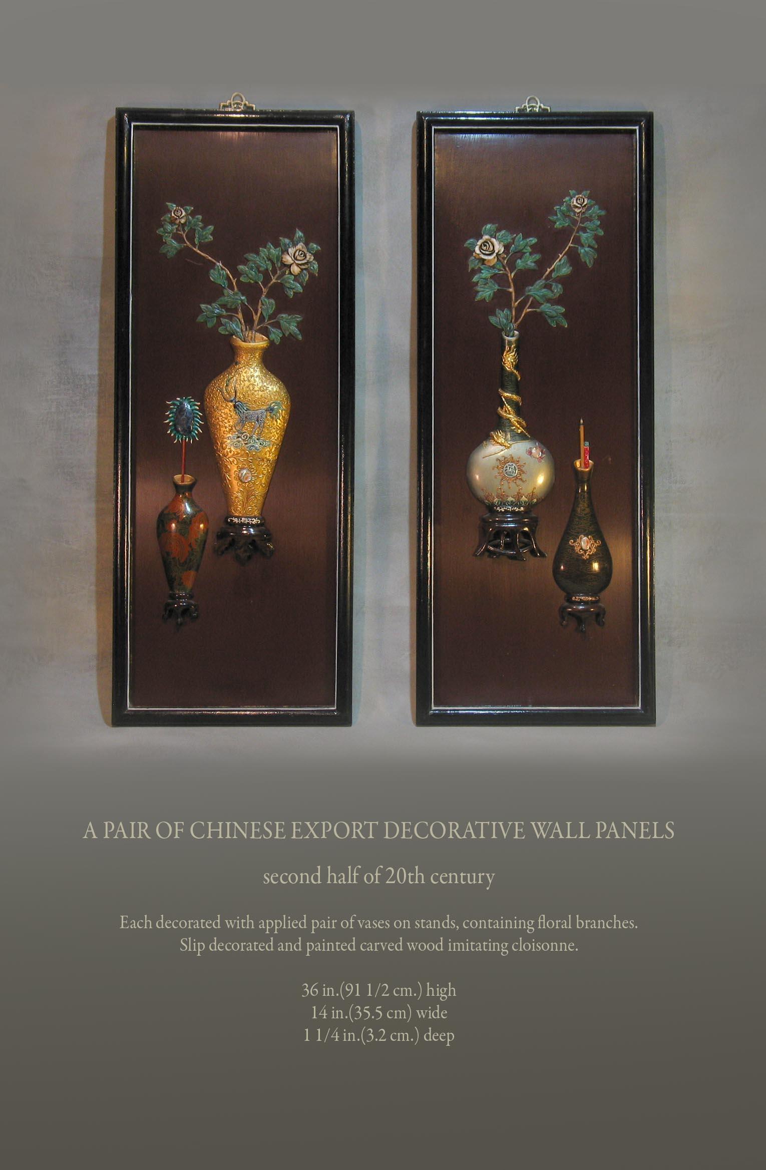 A pair of Chinese export decorative wall panels,

Mid-second half of 20th century.

Each decorated with applied pair of vases on stands, containing floral branches.
Slip decorated and painted carved wood imitating cloisonné.

Measures: 36 in.