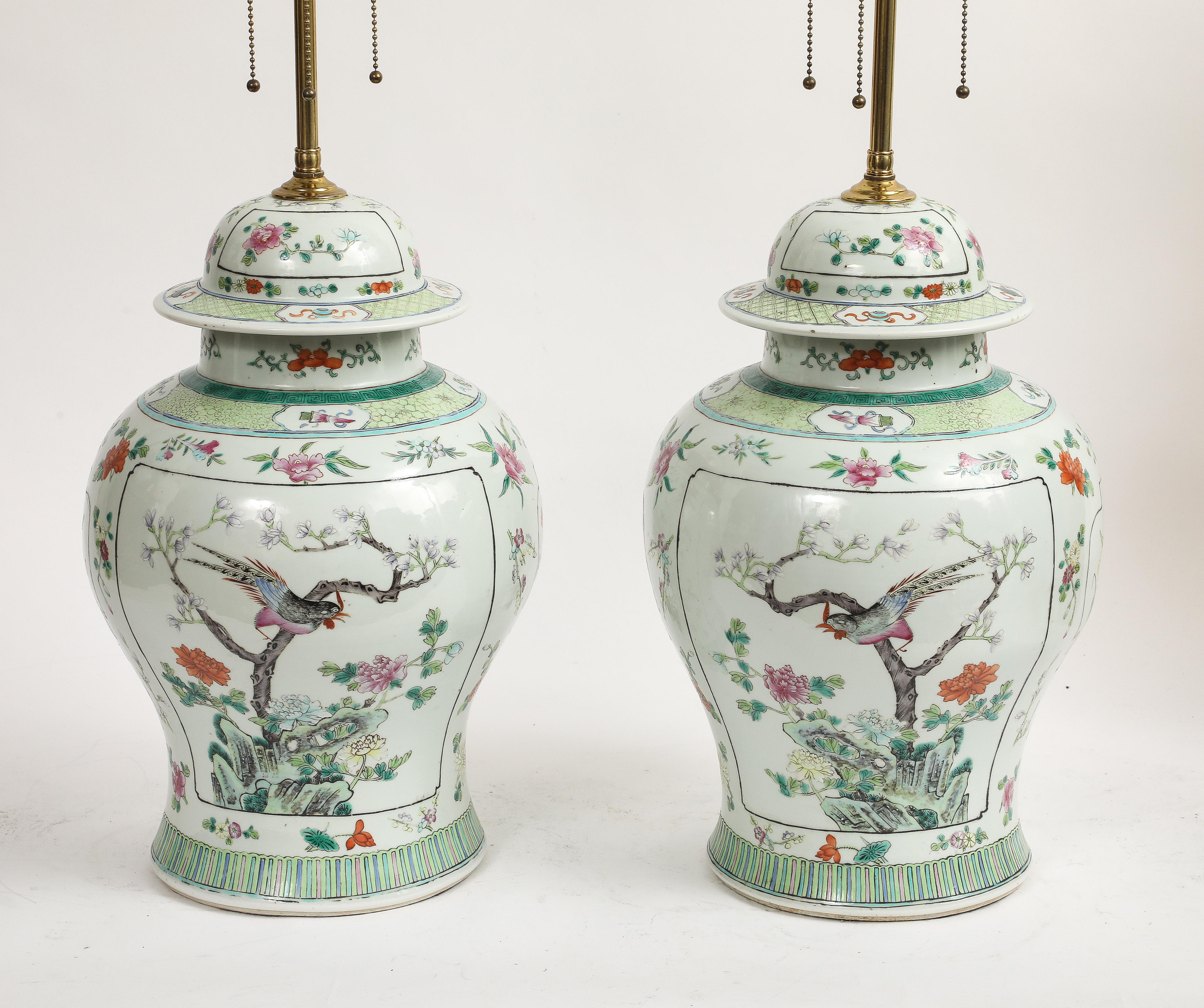 A Fabulous Pair of Chinese Famille Verte Porcelain Covered Ginger Jars Mounted as Lamps.  Each is of baluster form, with a domed lid and wide, slightly everted rim, mounted as table lamps with brass hardware. The porcelain bodies are decorated in