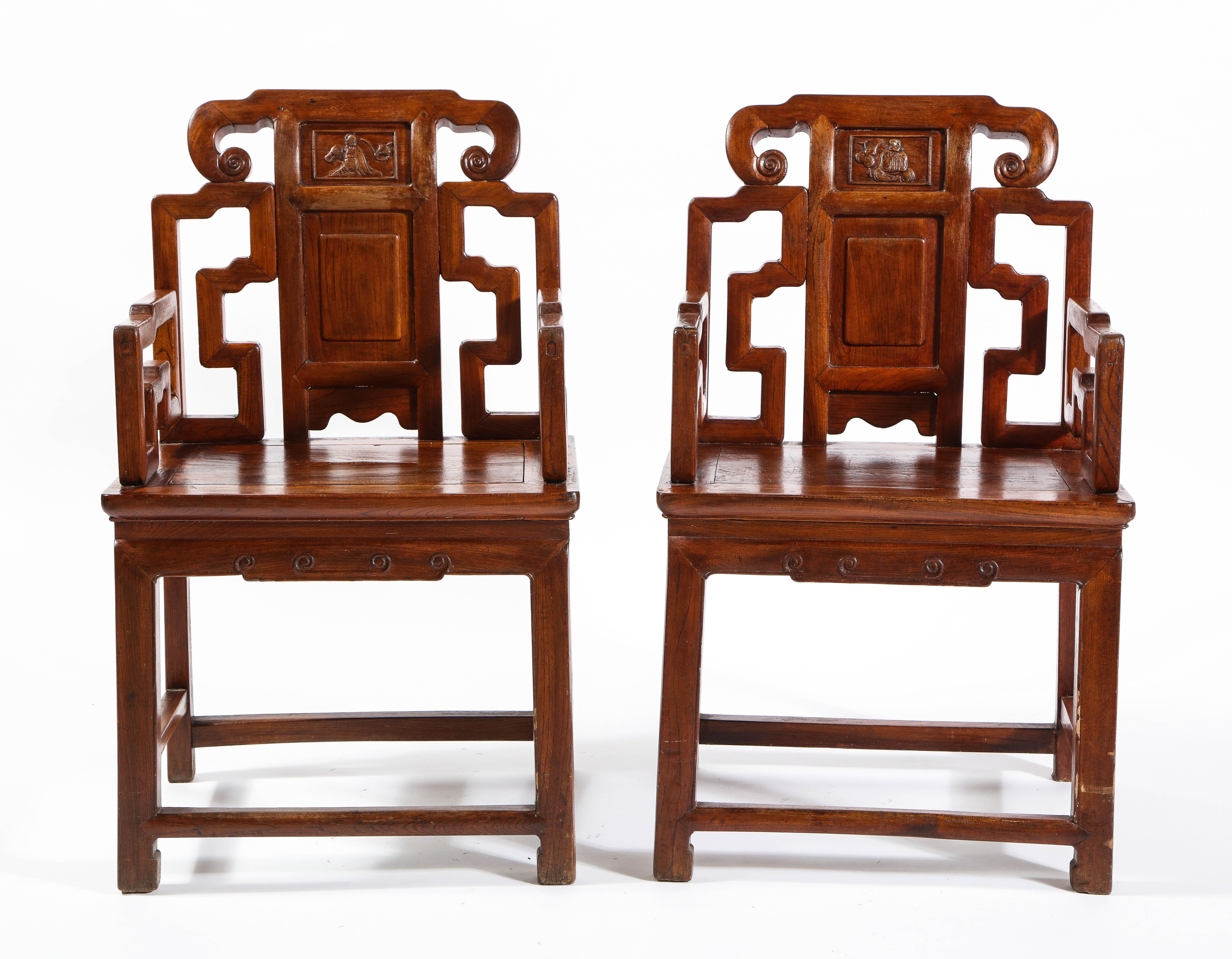 A pair of antique Chinese hardwood chairs with Fretwork designs and high relief panels. Each chair is beautifully hand carved with exceptional detail and craftsmanship. The wood is of the finest quality and has a gorgeous deep colored grain. On the