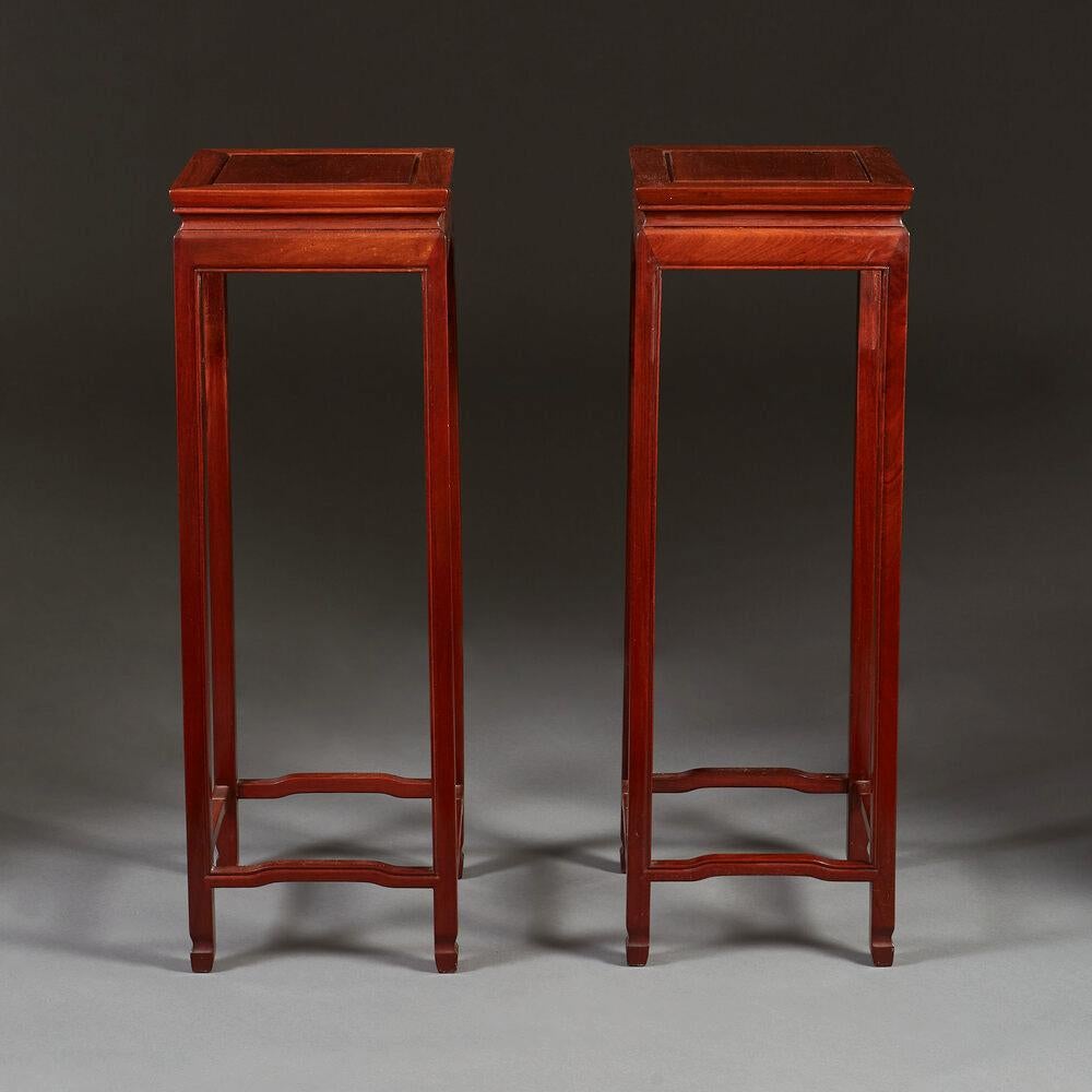 An early twentieth century pair of hardwood pedestal tables, with shaped stretchers.