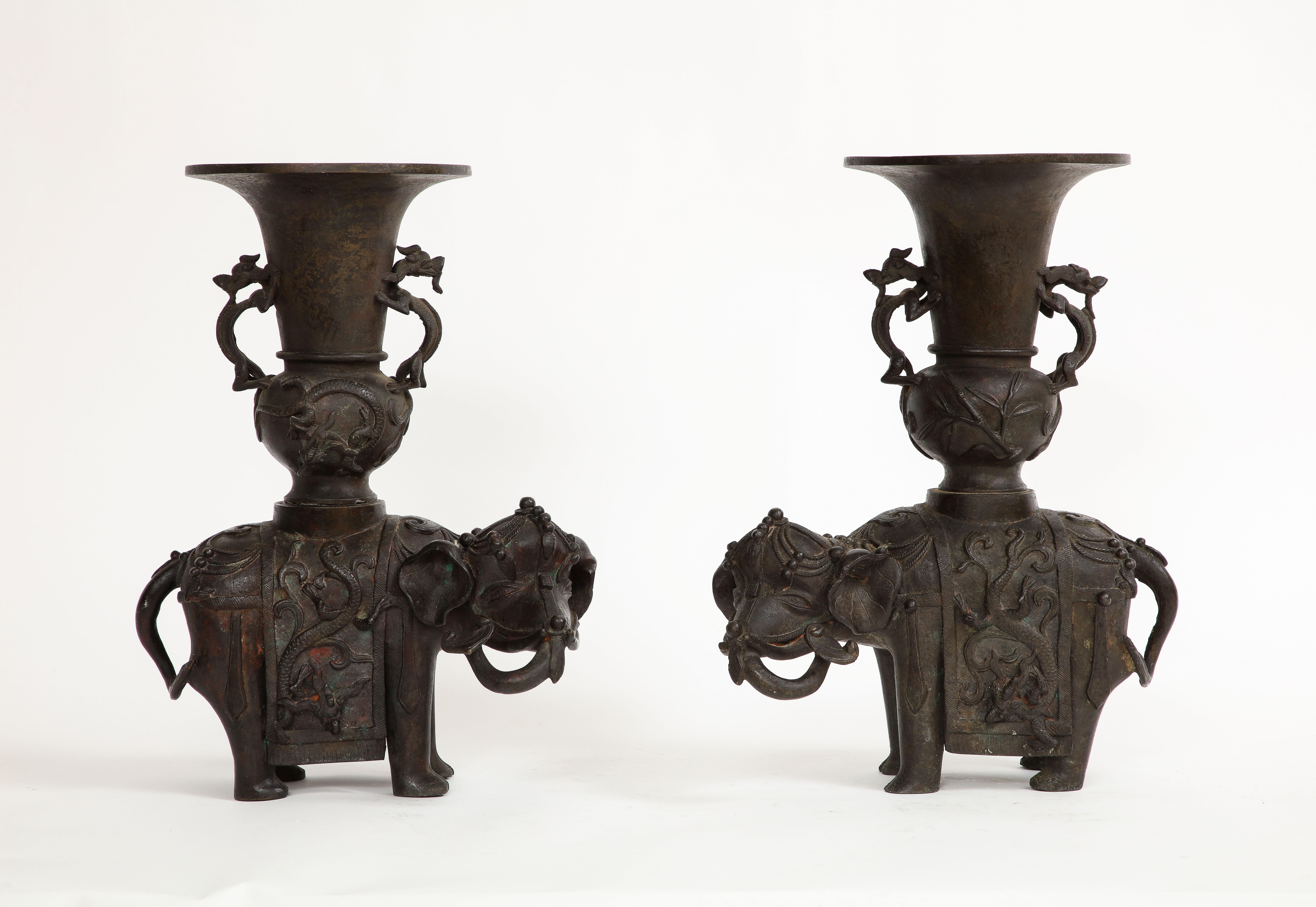  Coppia di vasi/incensieri a forma di elefante in bronzo patinato del periodo Ming cinese. L'elefante ha un abito buddista con gualdrappa di perle, nappe e una coperta con motivi di draghi ad alto rilievo. Sul retro si trova un vaso bulboso