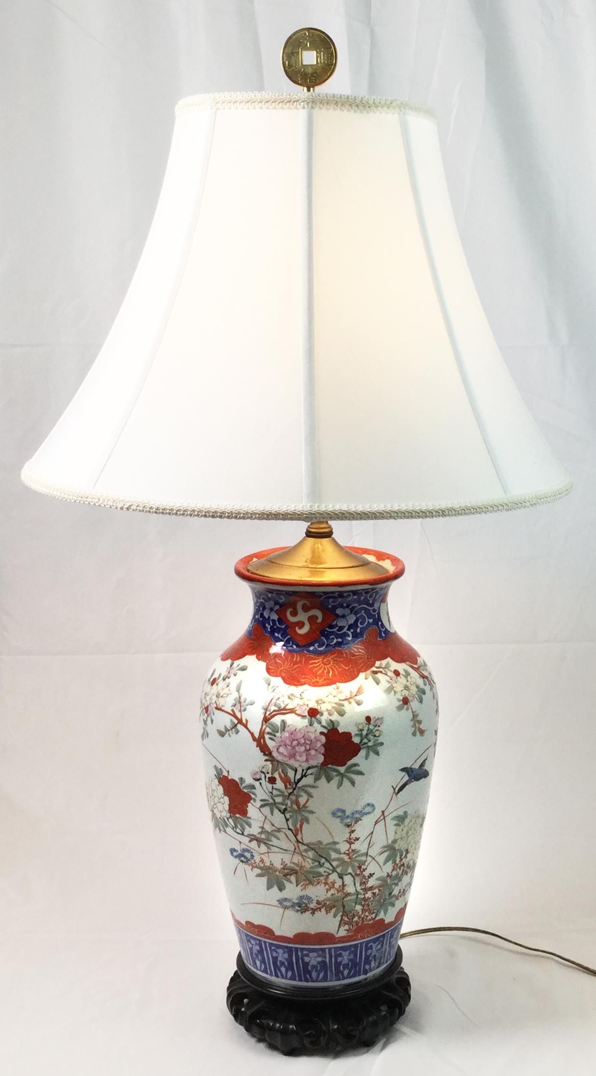 A pair of hand painted Chinese porcelain lamps with decoration of birds, flowers and branches on a white porcelain background . The shades are for photographic purposes only, not included. The total height with a shade is 32 inches, to the top of