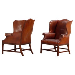 A pair of Chippendale style leather wing chairs C 1910.