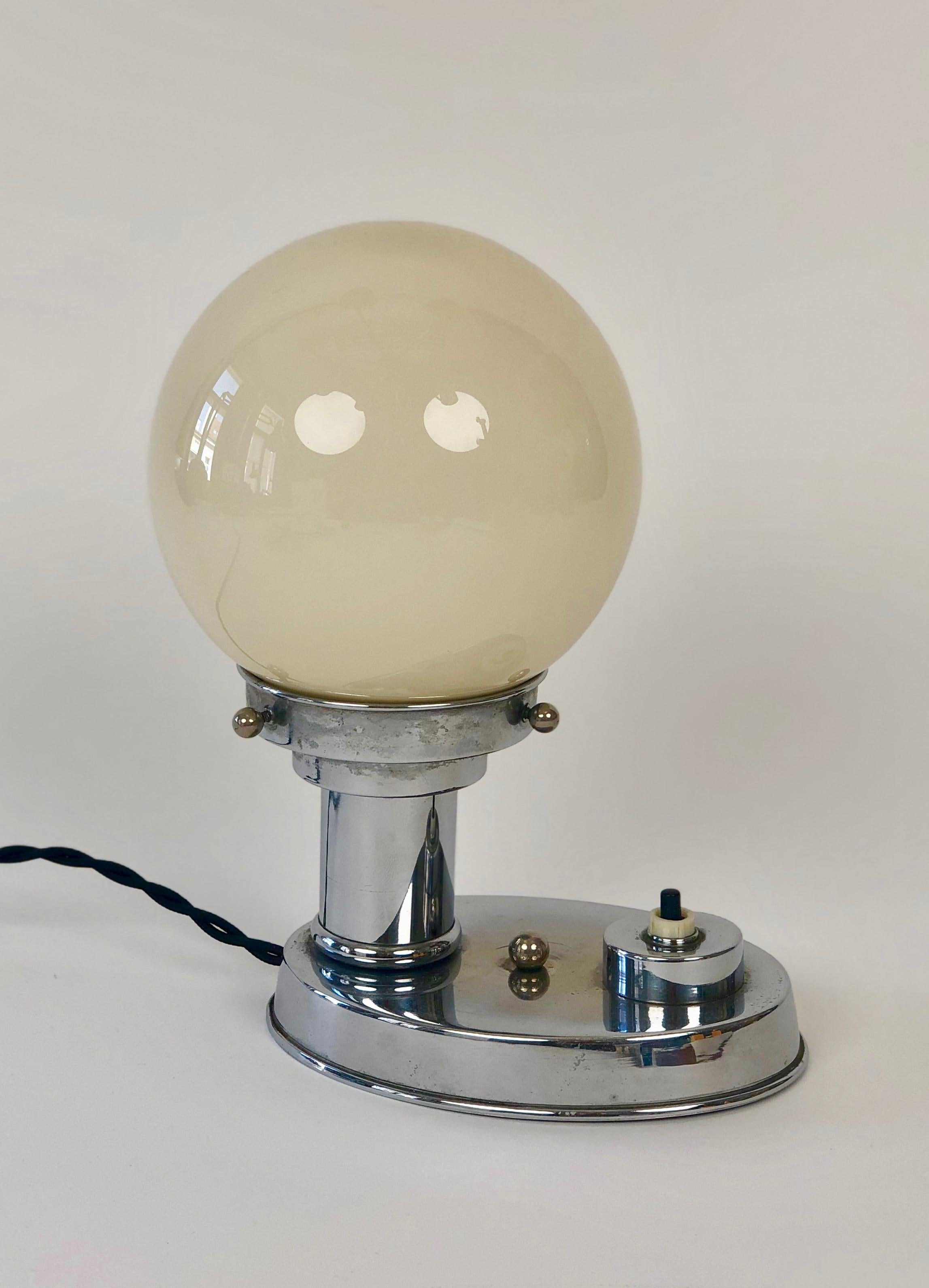 Paire de lampes de table Art Déco chromées des années 1930. 
Le chrome des deux lampes est en très bon état d'origine ; nous avons remplacé le câble électrique par un câble torsadé noir provenant d'Italie. 
La boule de verre a une couleur chaude.