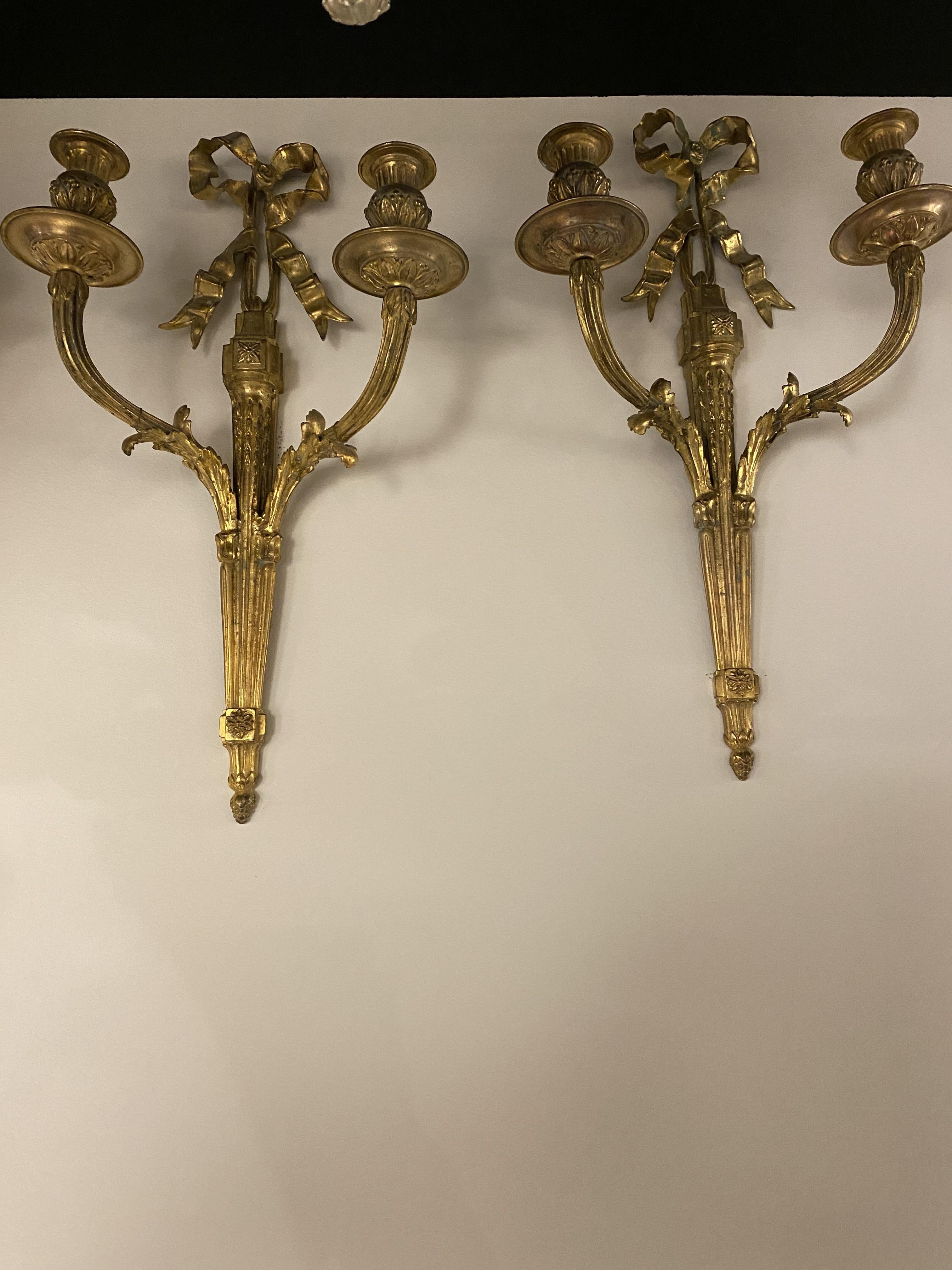 Coppia di appliques francesi in bronzo dorato del 1900 circa con nastro in alto