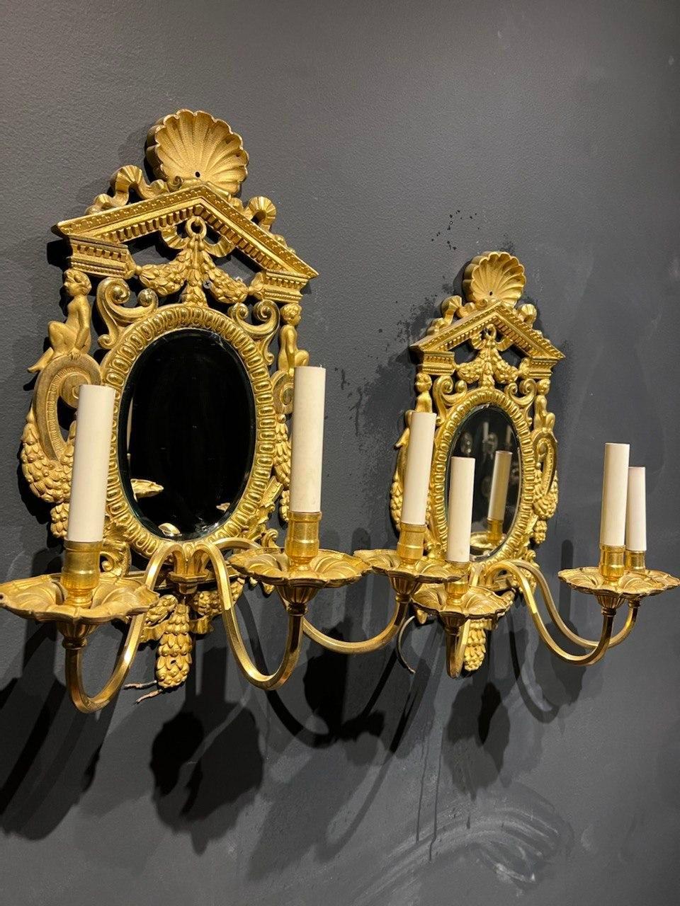 A pair of large 1900's neoclassic style gilt bronze Caldwell sconces with beveled mirror backplate, 3 lights