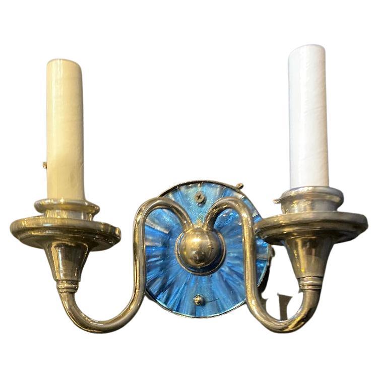 A pair of circa 1920's Caldwell double light silver plated sconces with cobalt mirrored backplate