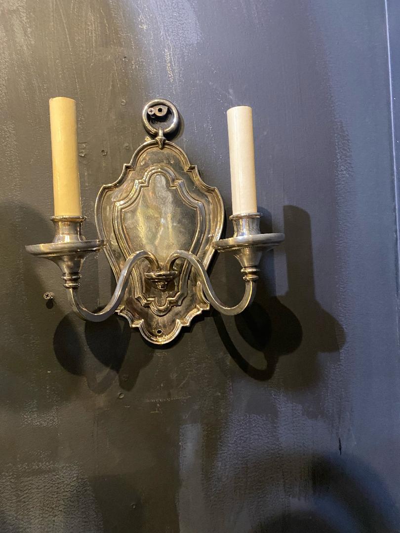 A pair of circa 1920's Caldwell silver plated double light sconces