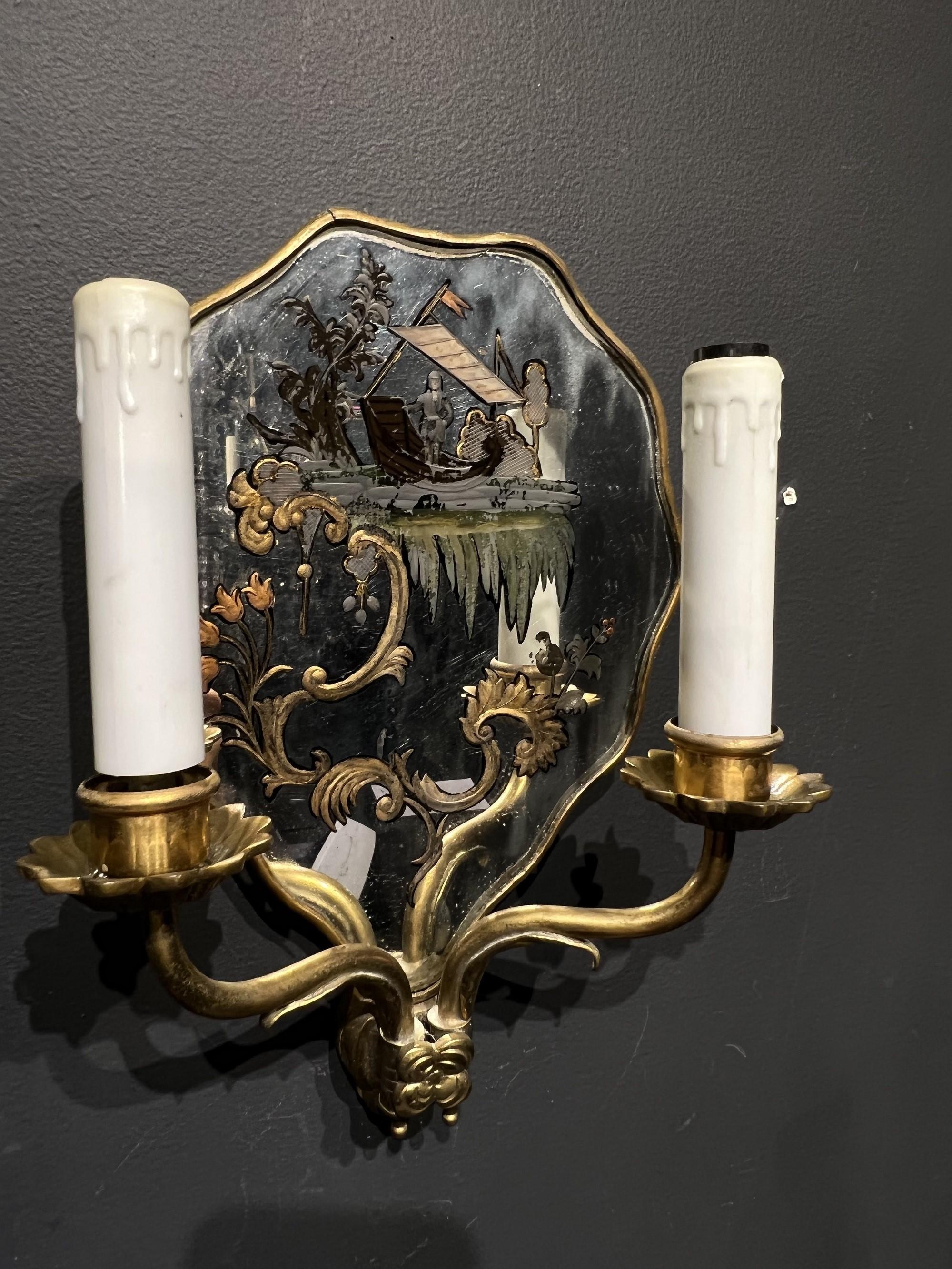 A pair of circa 1920's Caldwell double light sconces with reverse painted mirrored backplate