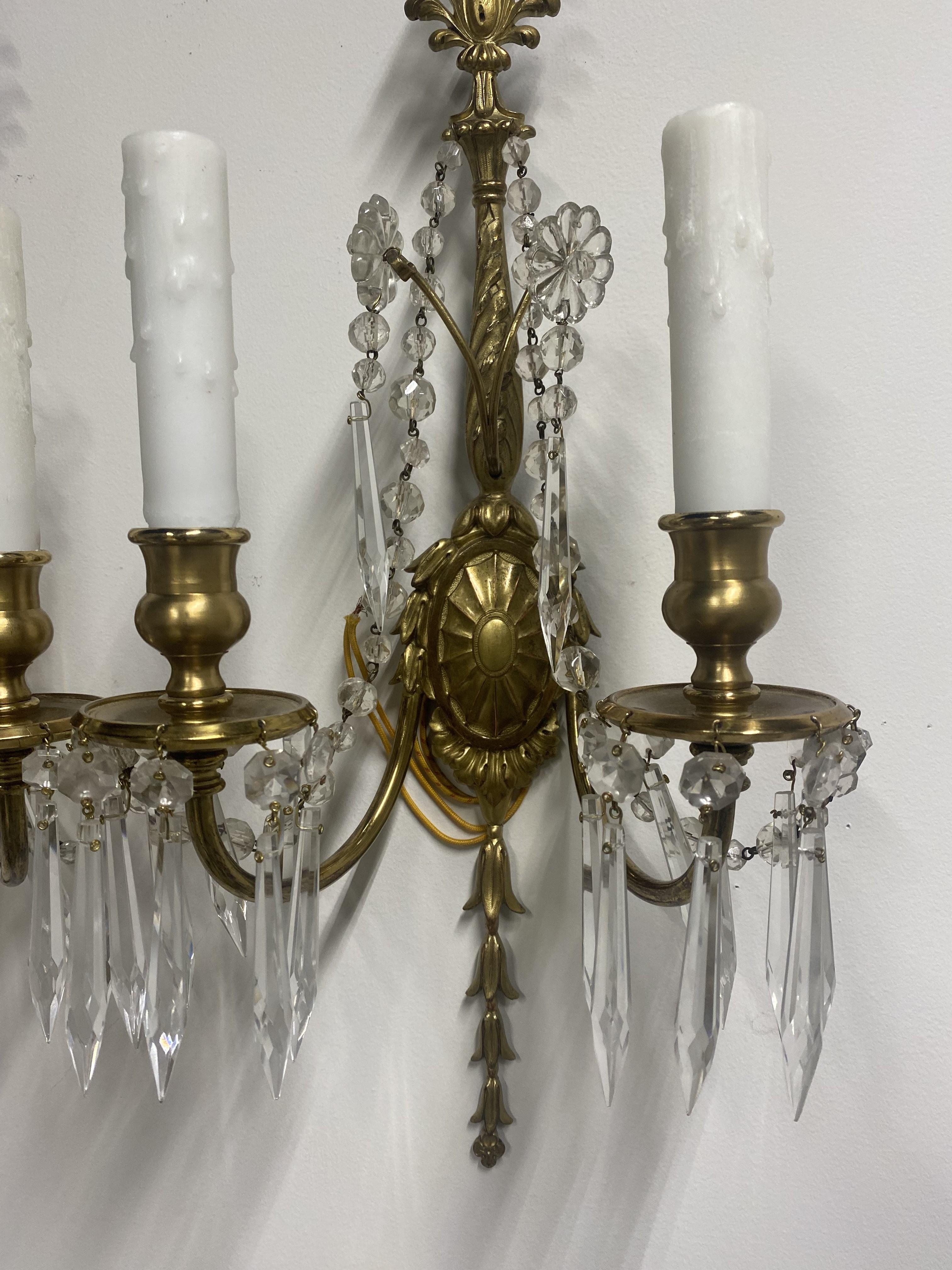 A pair of circa 1920's Caldwell gilt bronze sconces with crystal hangings
