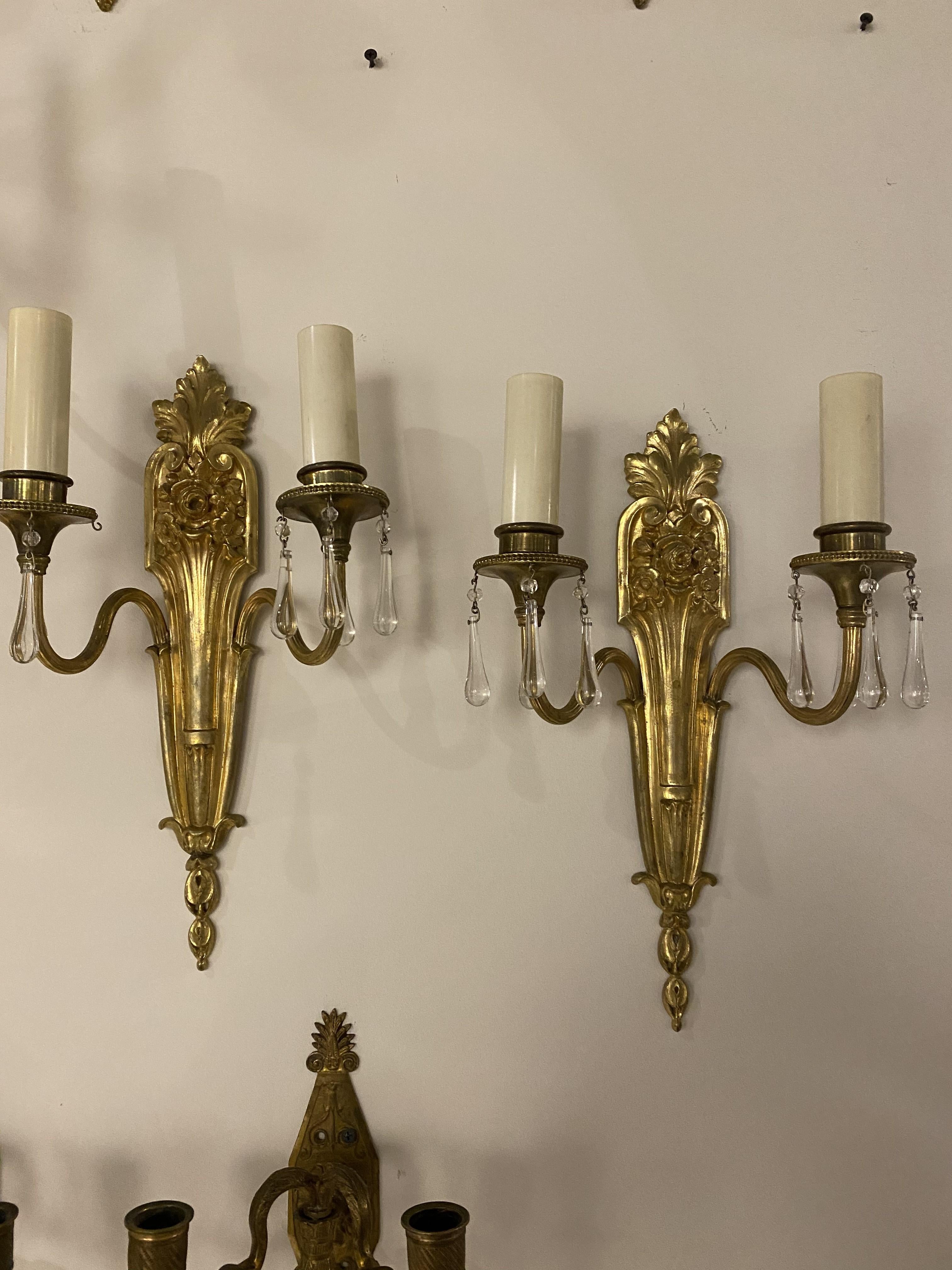 A pair of circa 1920's Caldwell gilt bronze double light sconces with crystal drops. 