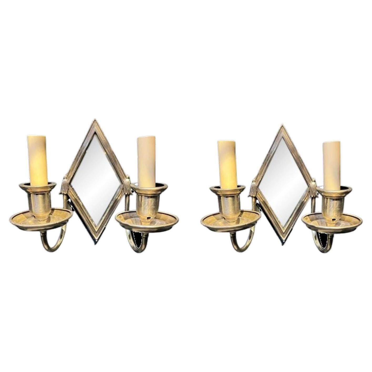 A pair of circa 1920 small Caldwell silver plated diamond shape sconces with mirrored backplate