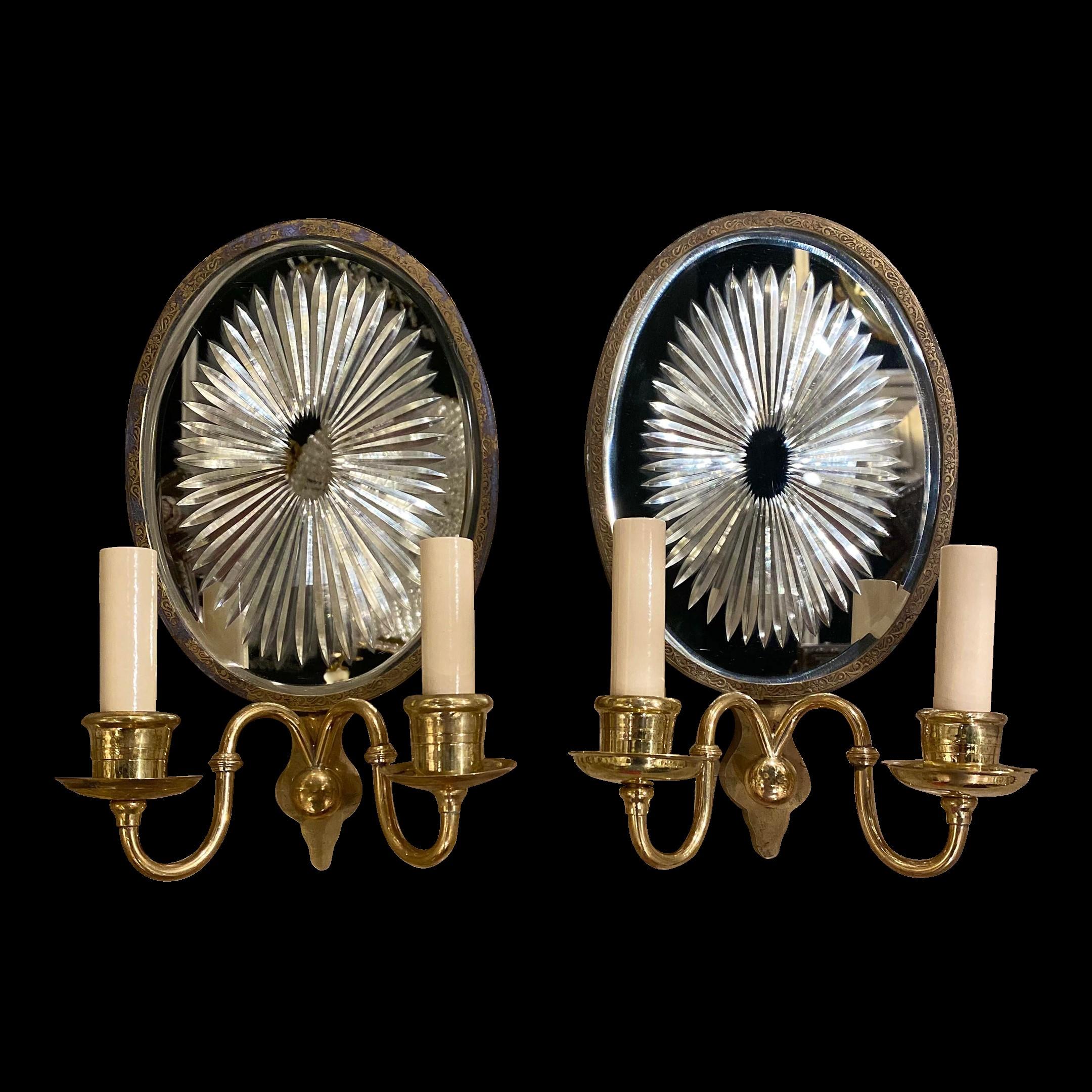 A pair of circa 1920's Caldwell double light sconces with sunburst shaped etched mirrored back plate