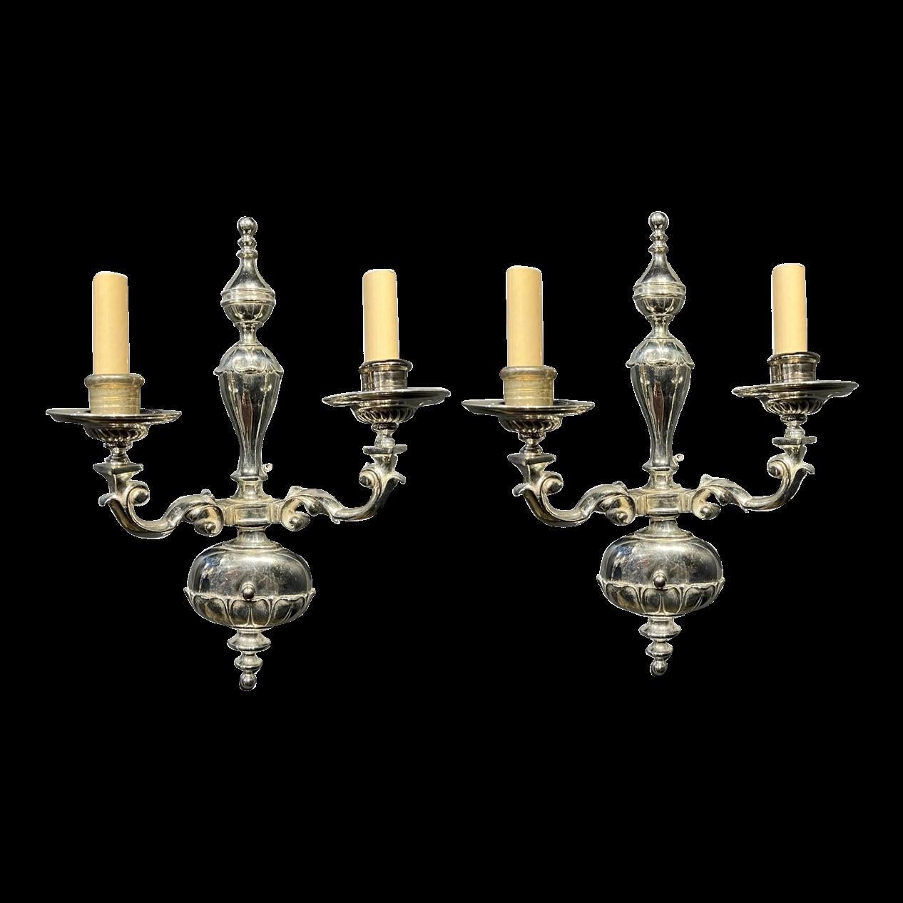 A pair of circa 1920's Caldwell silver plated sconces with two lights. Original finish.