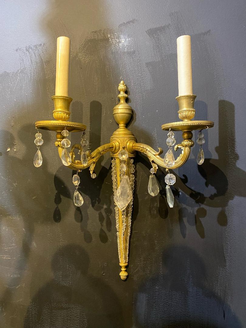 A pair of circa 1930's French gilt bronze sconces with beaded crystal body and rock crystal hanging