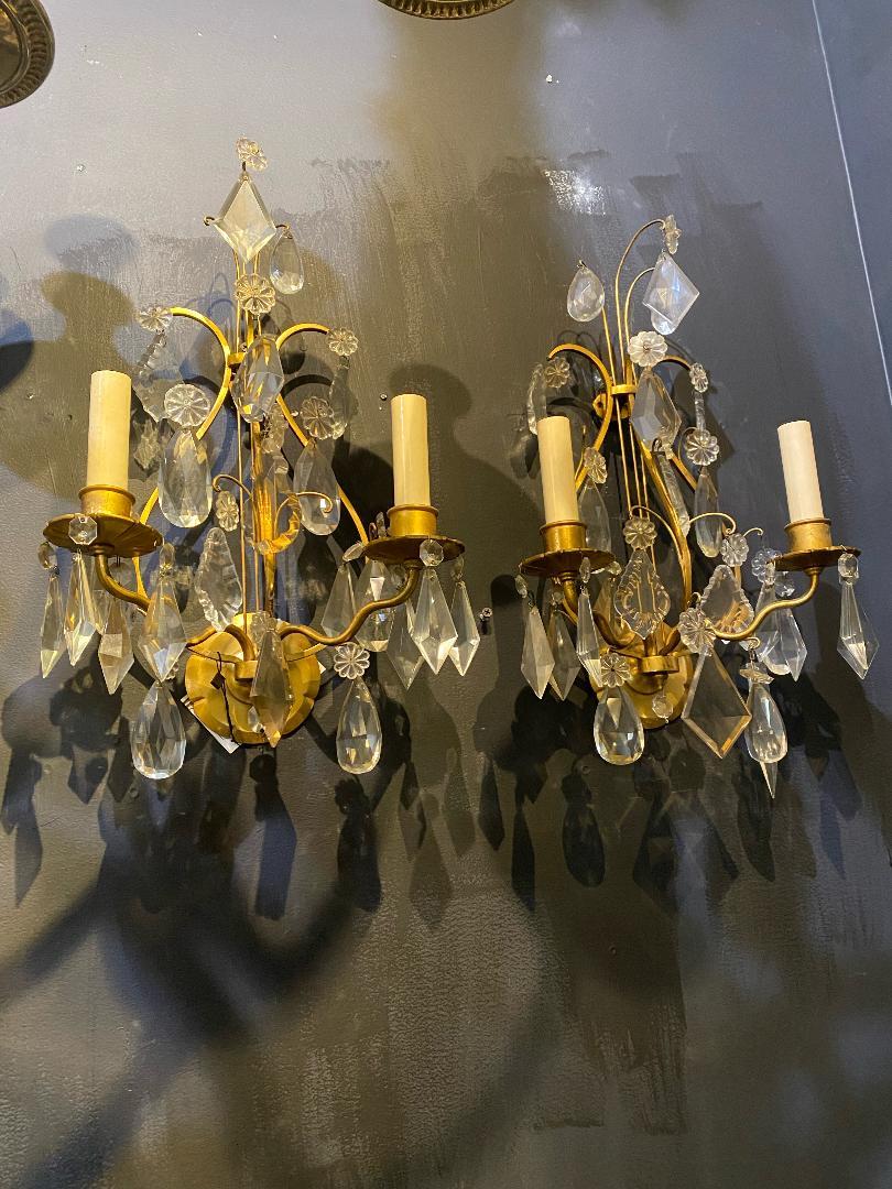 A pair of circa 1930's French gilt bronze lyre shaped sconces with crystal hangings