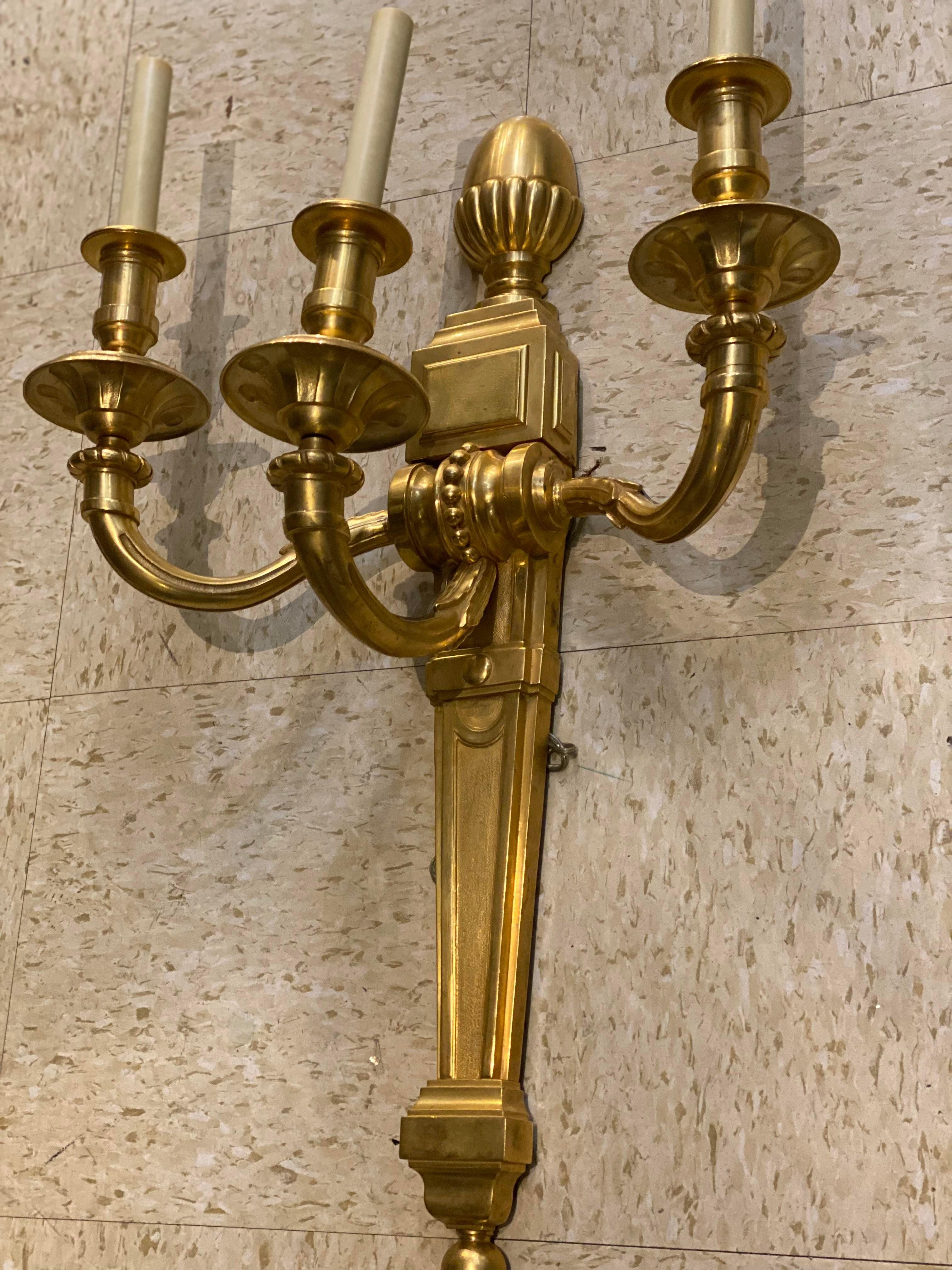 A pair of circa 1930's French gilt bronze sconces with three lights, from Waldorf Hotel NYC.