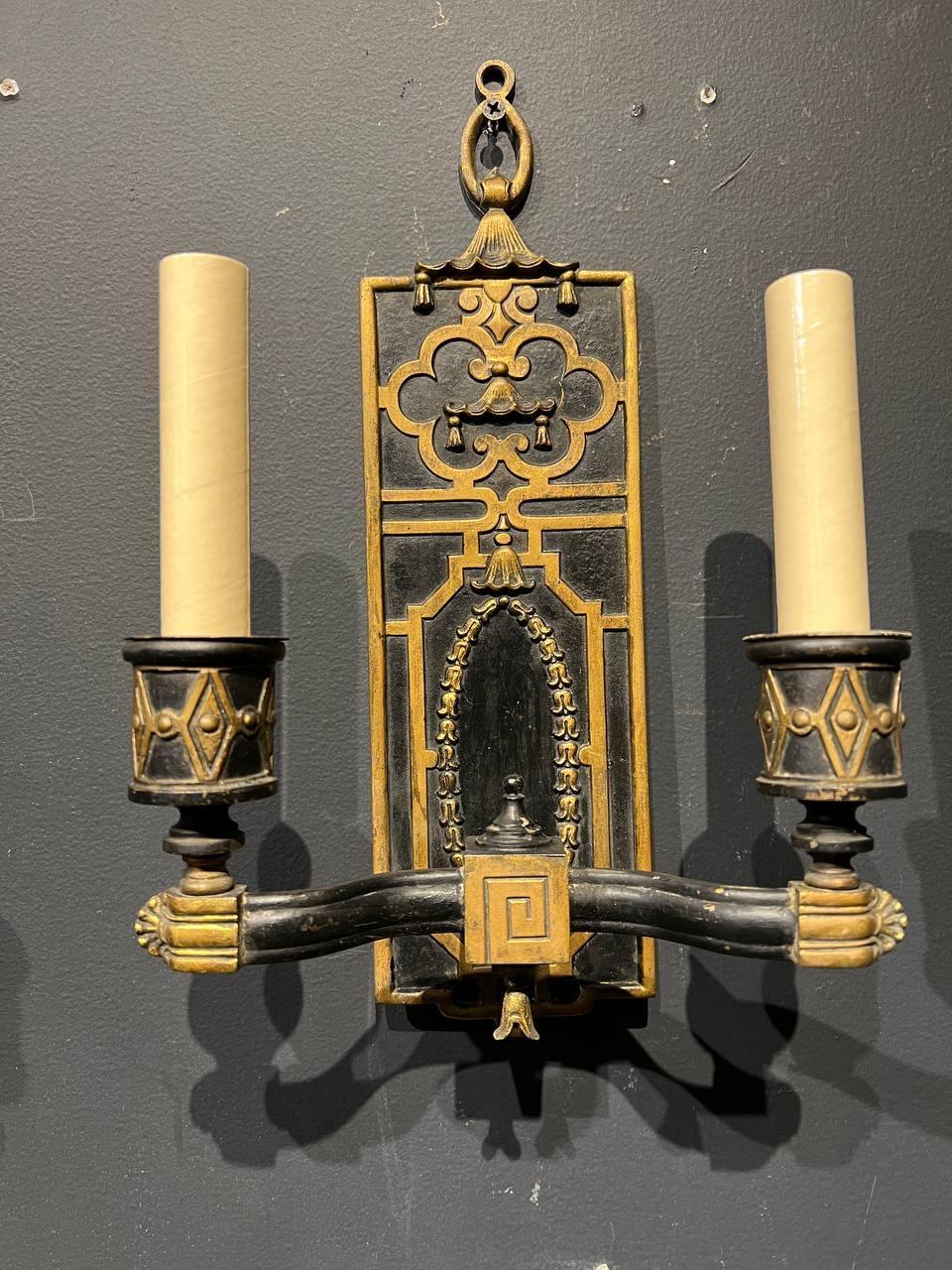 A pair of circa 1920's gilt bronze pagoda style double light sconces with scrolled arms.