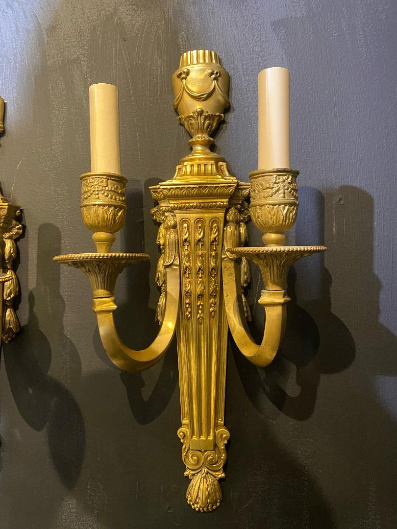 A pair of circa 1940's English neoclassic style gilt bronze sconces.