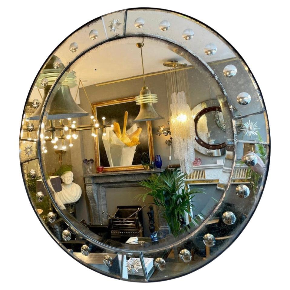 Paire d'appareils de style ancien  Grands miroirs circulaires biseautés avec bordure de miroir à panneaux en tôle légèrement vieillie, montés sur du bois qui a un bord en bandeau d'acier ébonisé. Décorée avec des séparateurs circulaires gravés, en