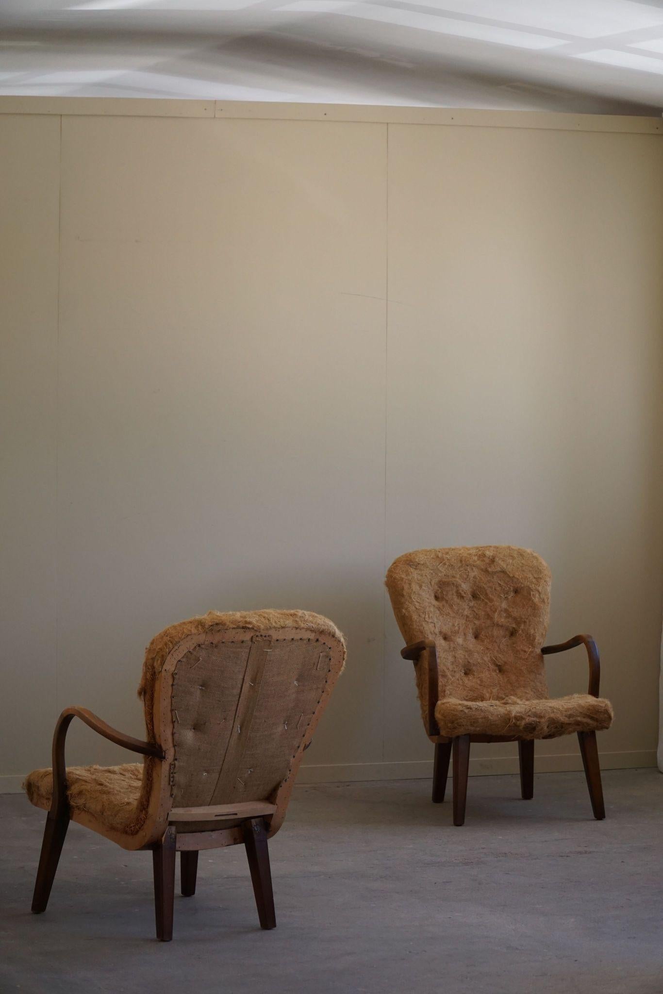 This captivating pair of lounge chairs, visually reminiscent of Arnold Madsen’s iconic ‘Clam Chair,’ is a splendid representation of Danish mid-century modern design. Crafted in the 1950s by a Danish cabinetmaker.
These chairs have been thoughtfully