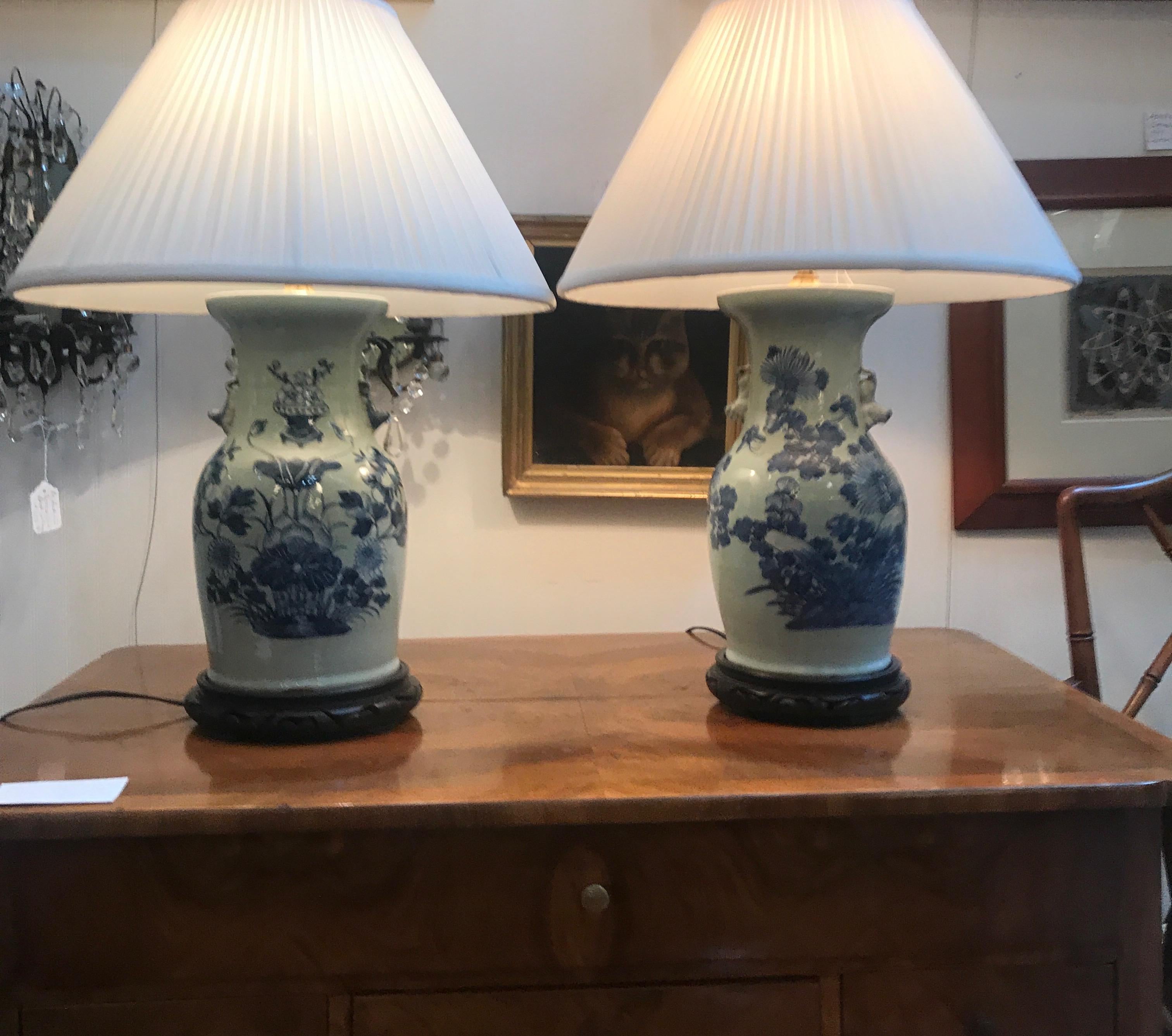 A pair of antique late 19th century Chinese vases now electrified. The grey white background with hand painted cobalt blue decoration with food bog handles. The shades are for photographic purposes only and not included. Total height with a shade,