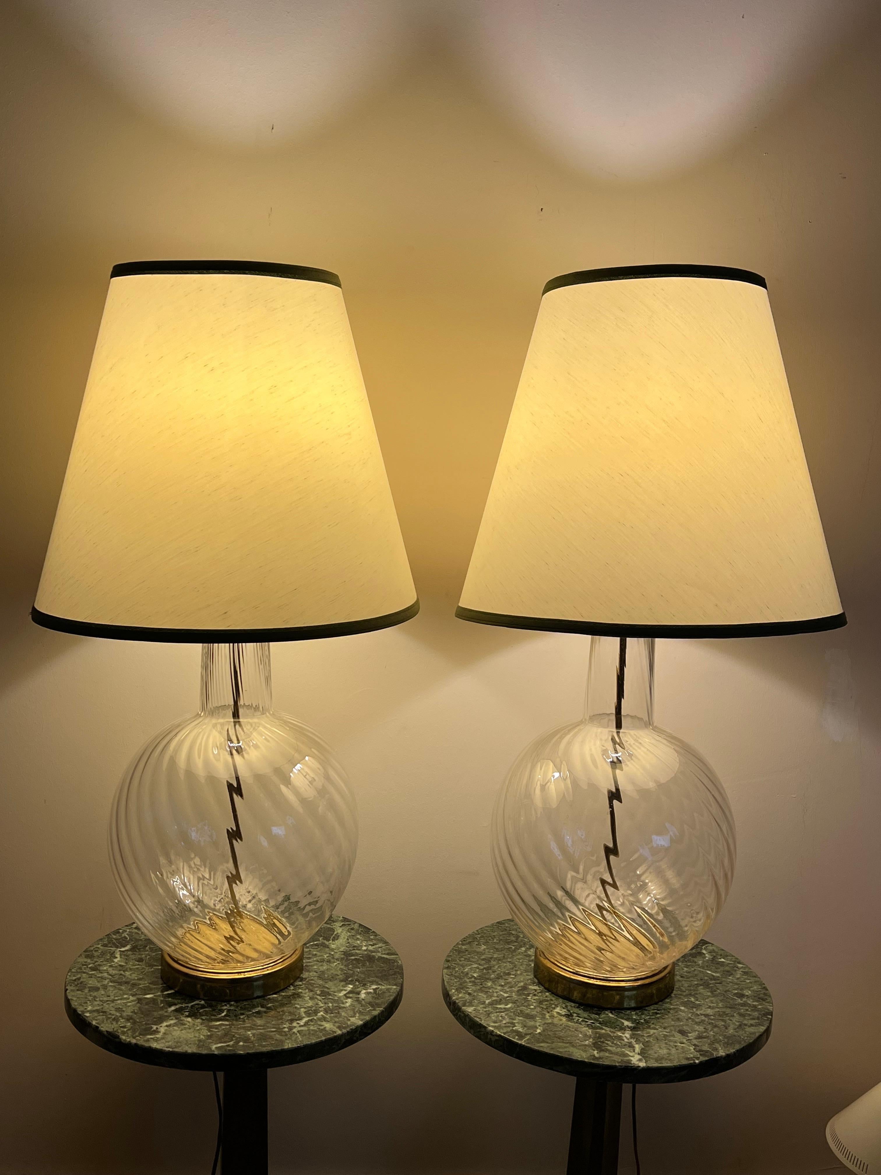 A pair of unusual, large scale clear glass Murano lamps ca' 1960's. Original brass fittings. Total height with shades 34