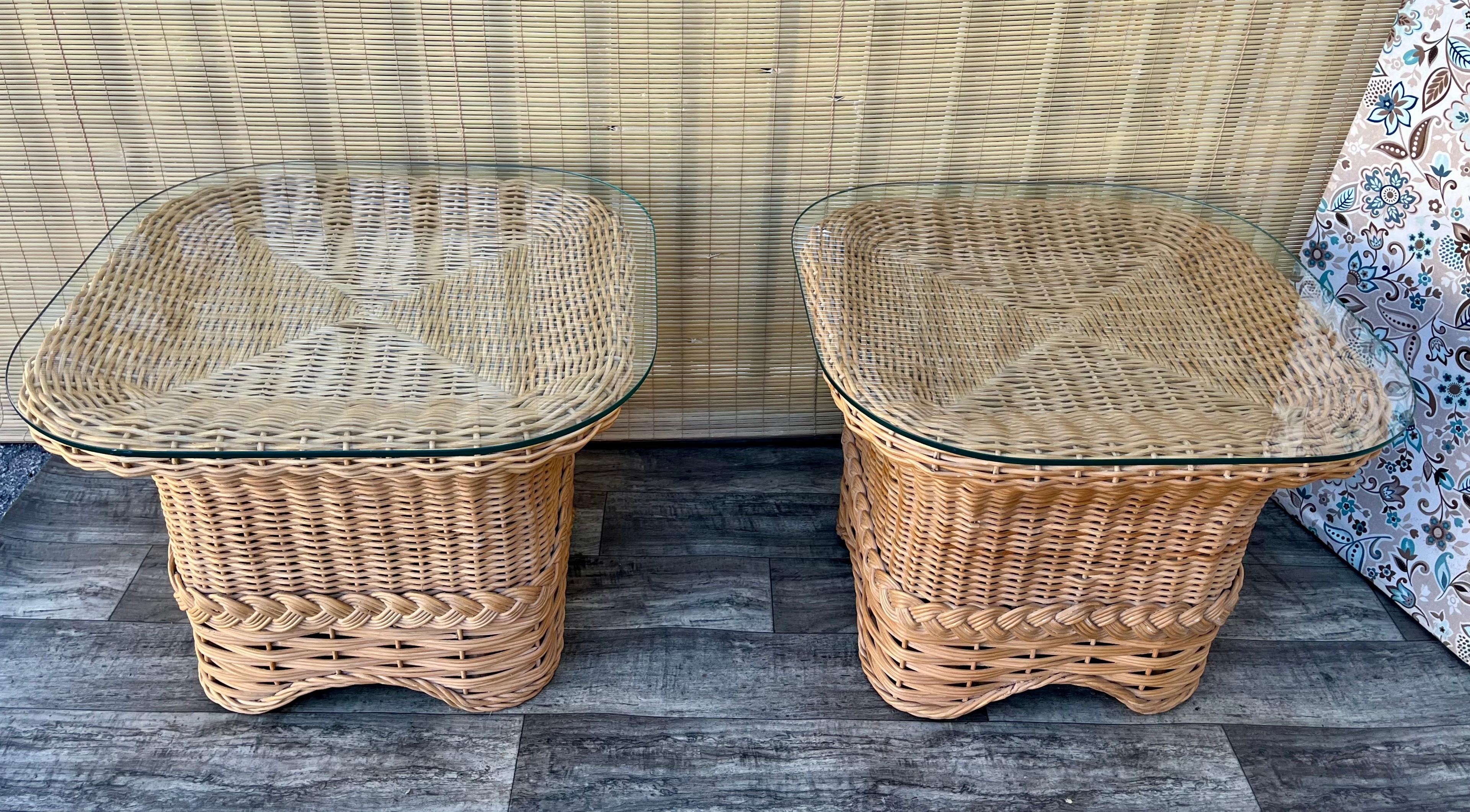 Paire de tables d'appoint en rotin tressé de style côtier. Vers 1980.
Les cadres en rotin de couleur naturelle sont ornés d'un magnifique galon et les plateaux en verre amovibles ont des bords arrondis. 
En excellent état d'origine avec de très