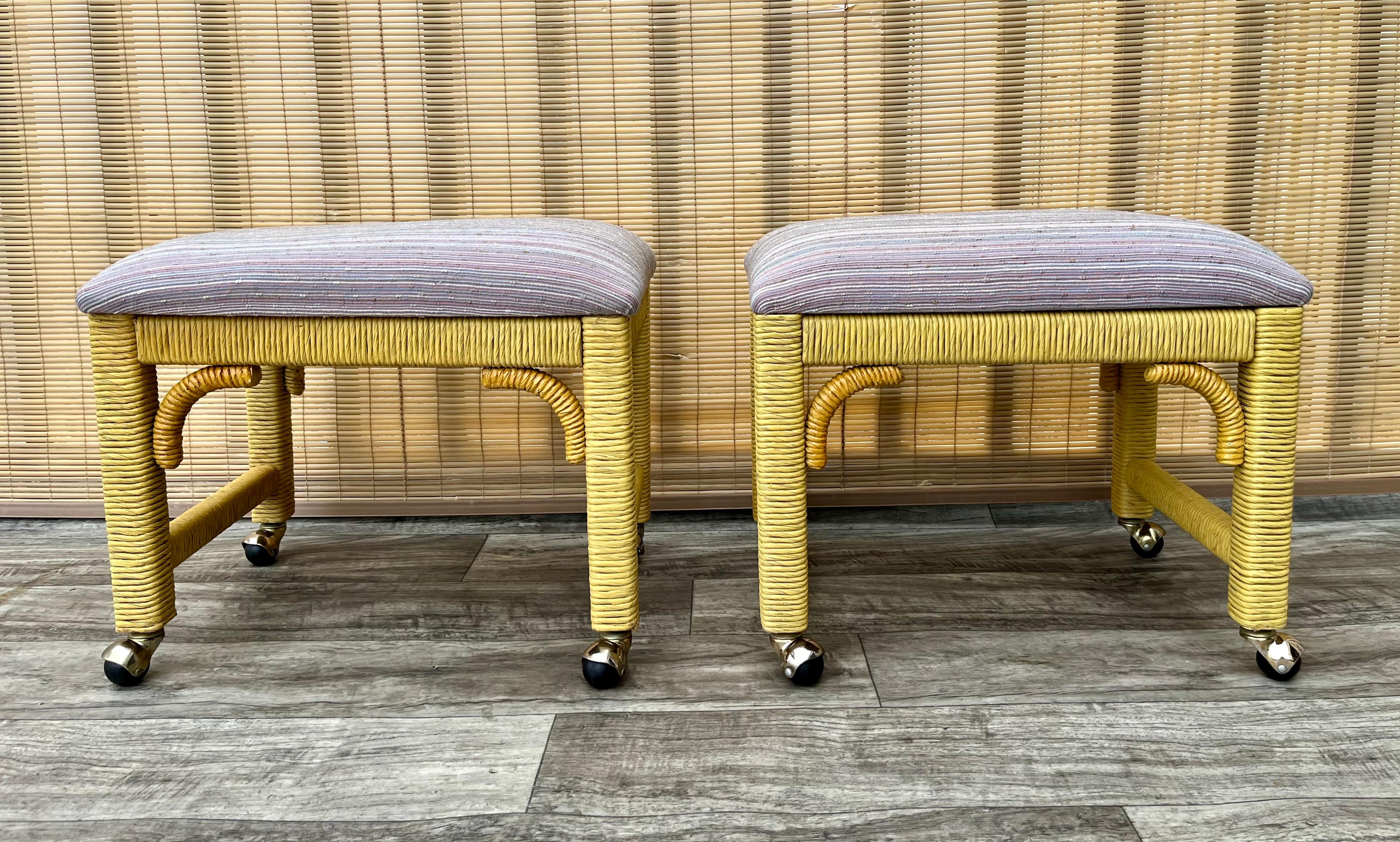 A Pair of Coastal Style Rolling Footstools/ Benches on Casters by Henry Link Furniture. Circa 1980s
Feature a wicker covered solid wood frame and a newly reupholstered cushions. 
In good vintage condition with very minor signs of wear and age.
Both