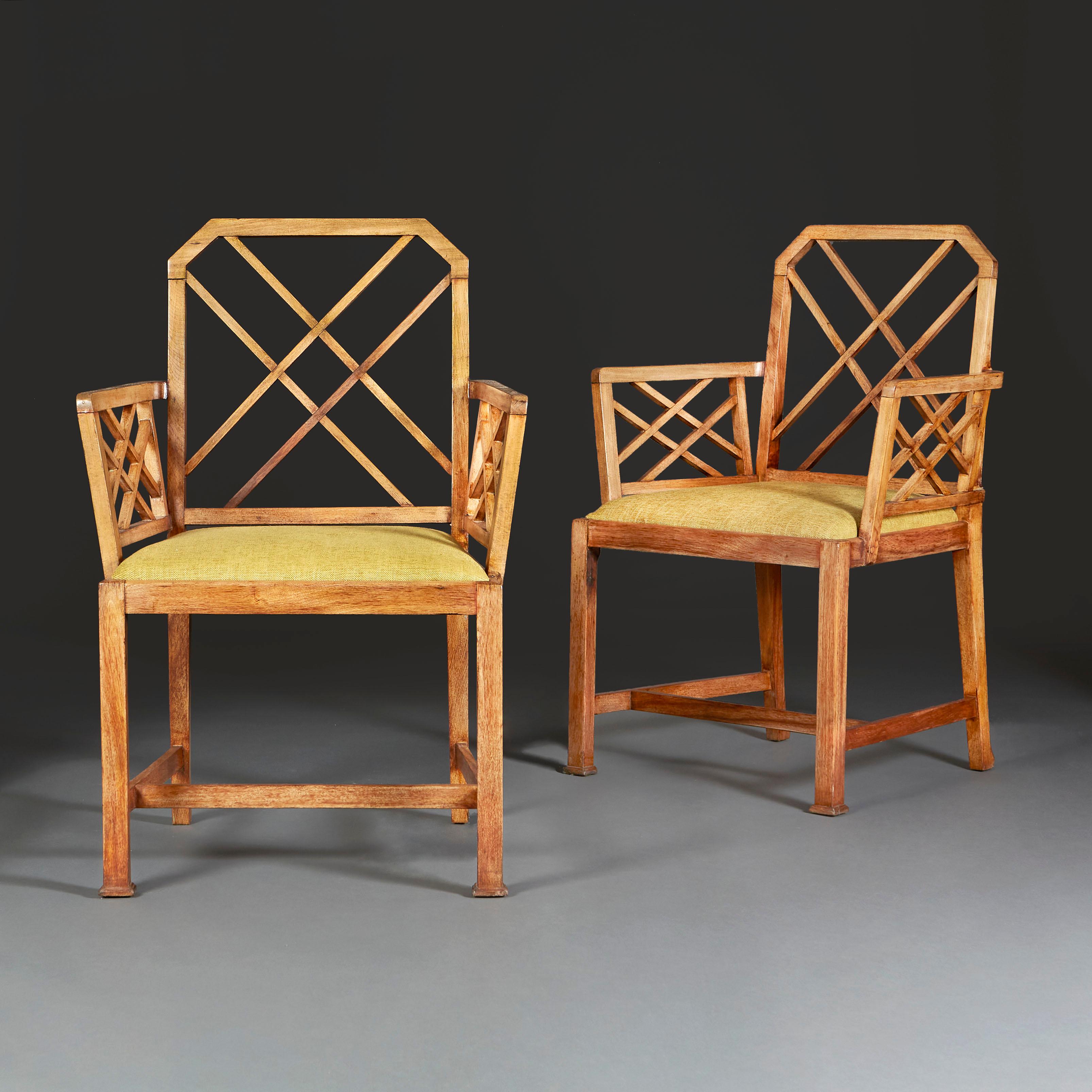 A pair of mid-twentieth century English oak cockpen armchairs with lattice backs and arms, the seats now upholstered in green linen.