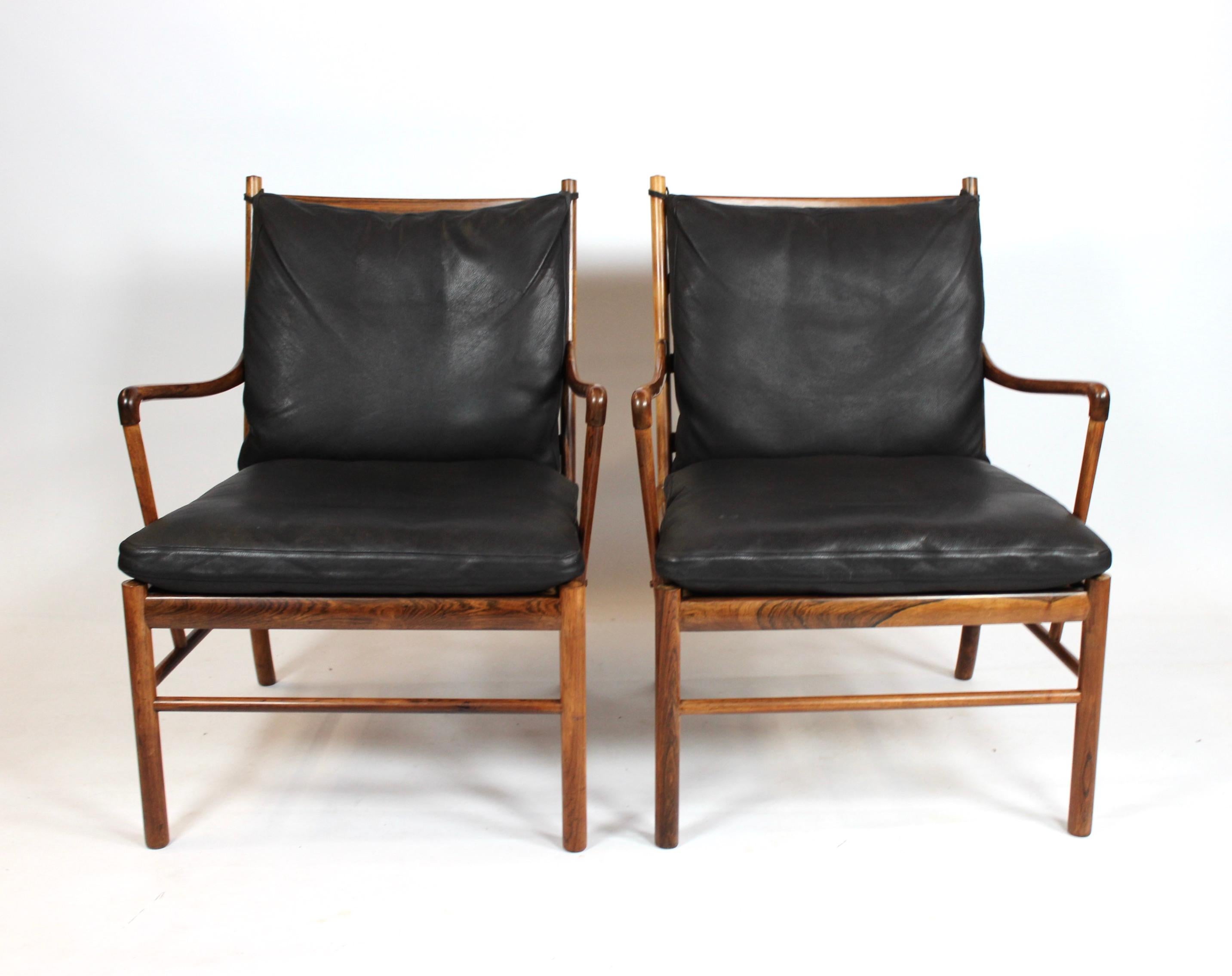 A pair of colonial easy chairs, model PJ149, designed by Ole Wanscher in 1949 and manufactured by P. Jeppesen. The chairs are of rosewood with cushions of black leather and both are in great vintage condition.