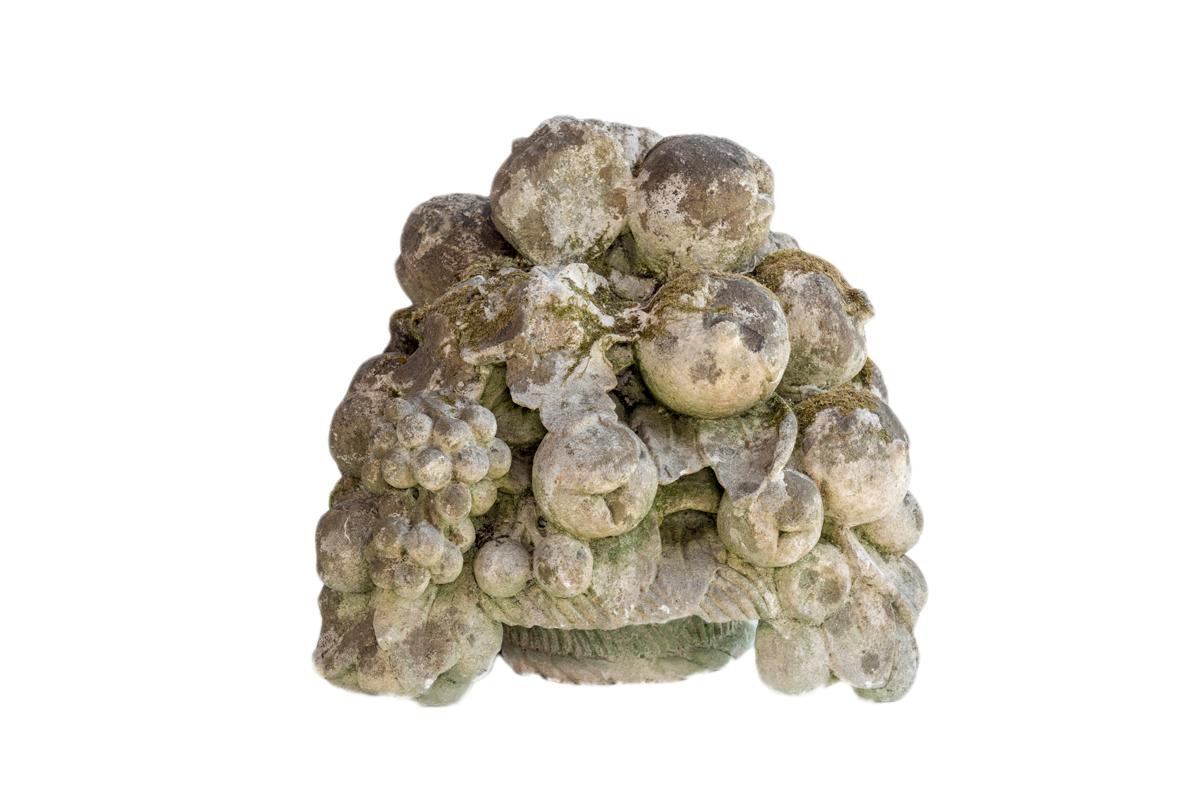 A pair of constitute stone basket of flowers and fruit with lichen.