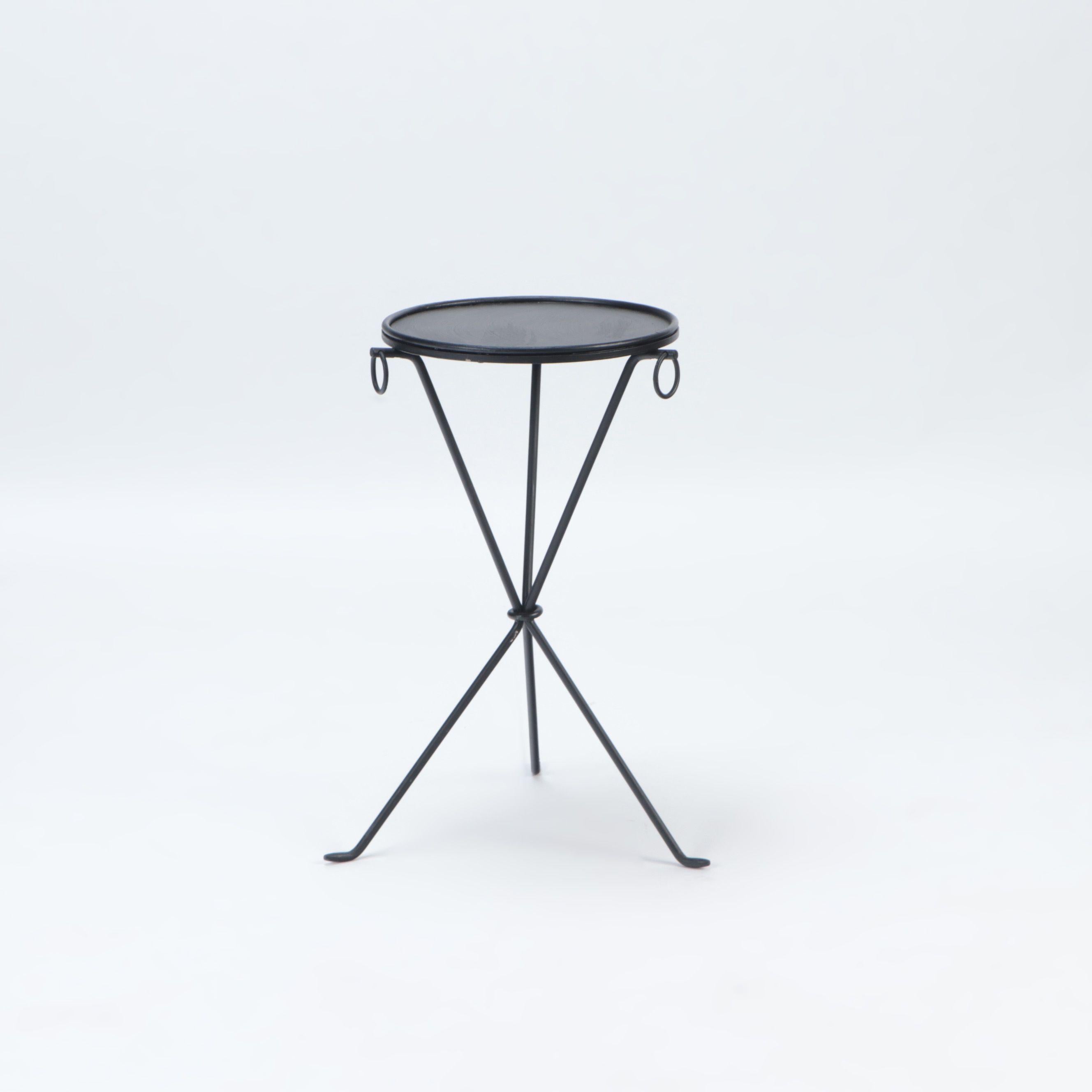 A pair of wrought iron drink tables in the manner of Jean-Michel Frank. The tables rest on a sleek tripod form base.