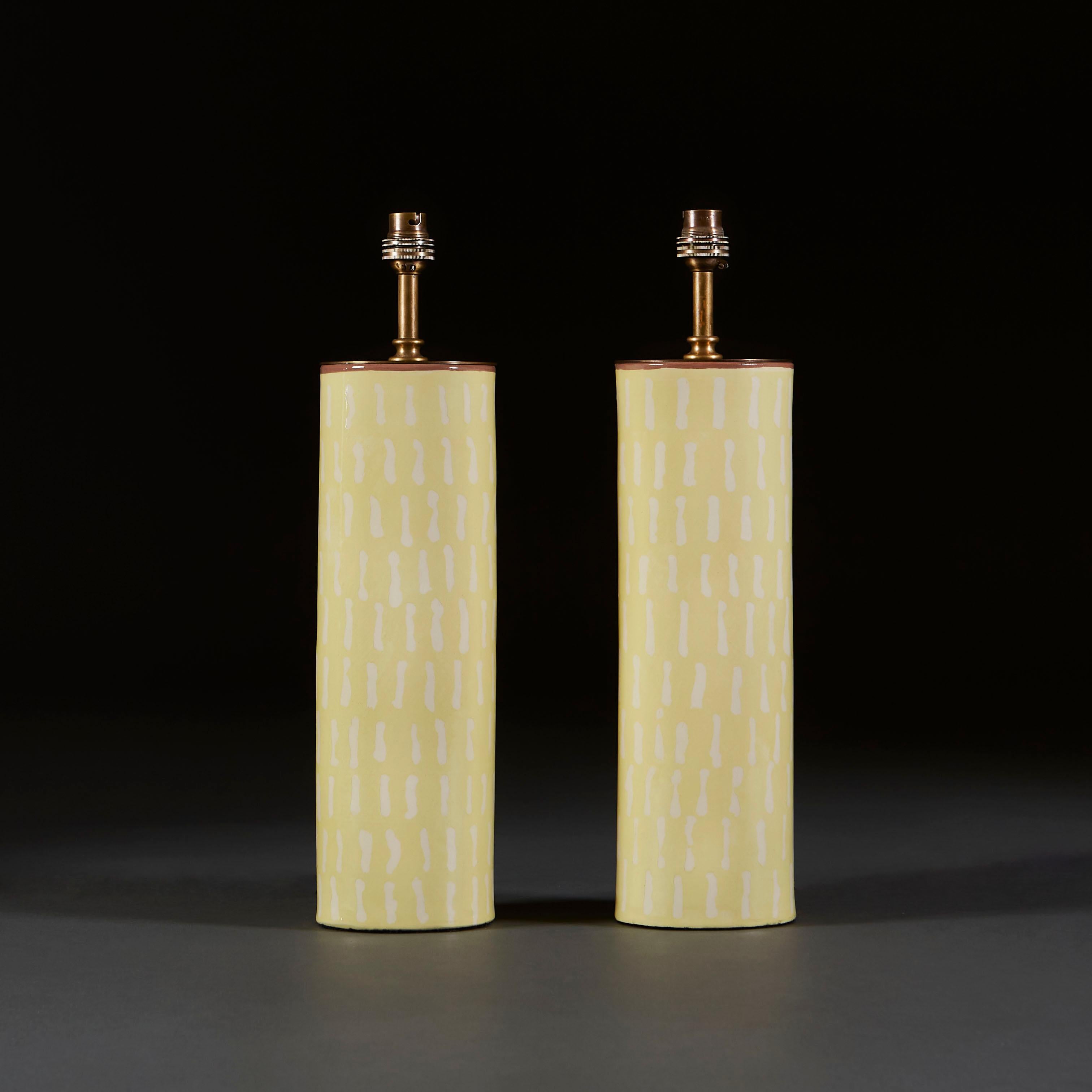 A pair of studio pottery vases made using white earthenware, now converted as table lamps, the yellow ground decorated throughout with white dashes, with contrasting brown rims to the tops. Hand made in the UK. 

Currently wired for the