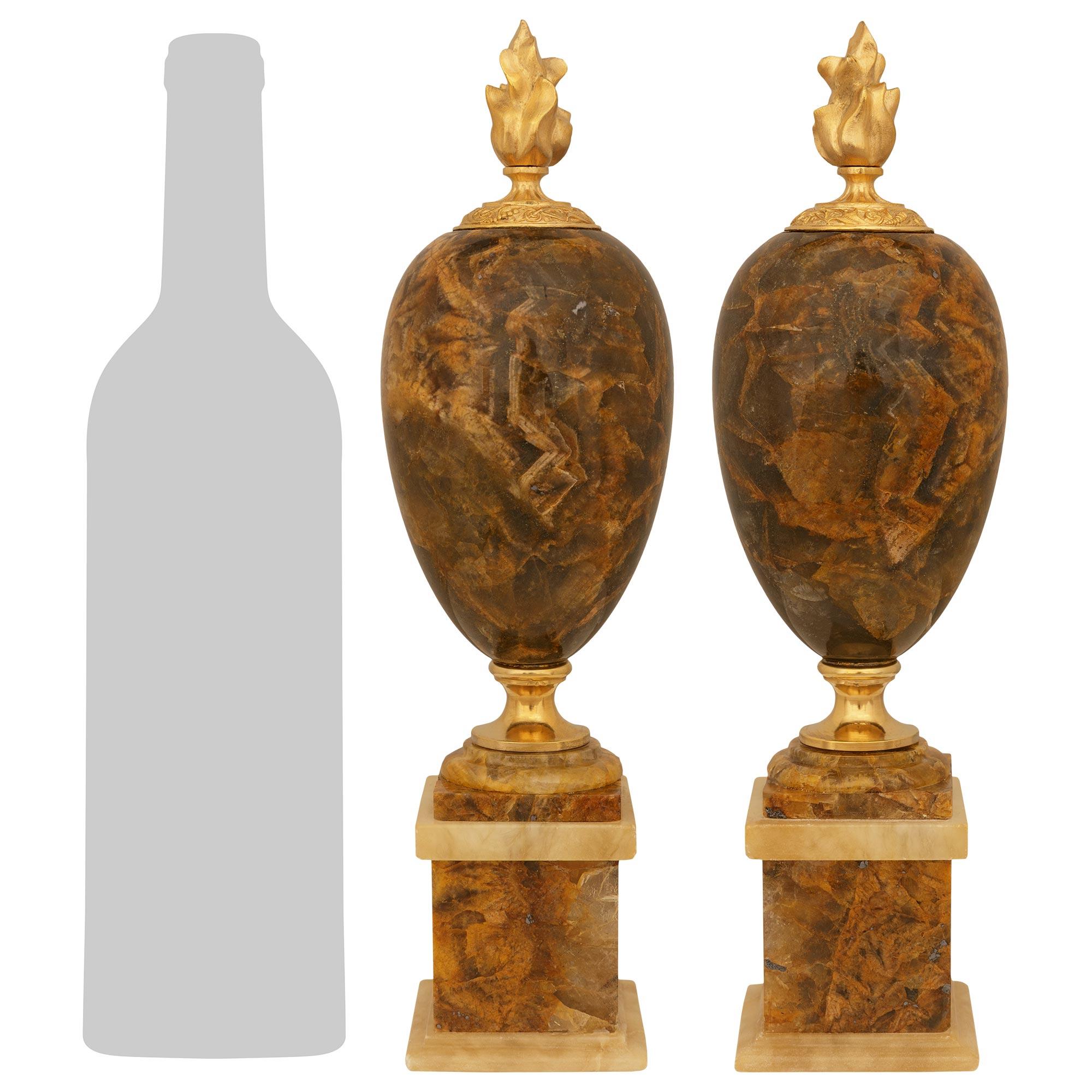 A sensational and high quality pair of Continental 19th century Blue John and Ormolu trophies. Each remarkable egg shaped trophy is raised by an attractive square plinth below a mottled socle and Ormolu support. The Blue John bodies are finished at