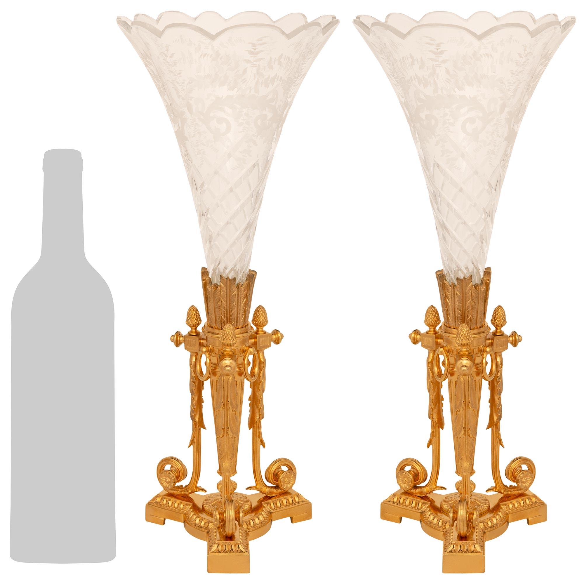 Una splendida coppia di vasi in cristallo inciso e ormolo del XIX secolo di St. Louis Crystal, splendida e finemente dettagliata. Ogni vaso è sollevato da una base triangolare in Ormolu screziato con estremità squadrate, lati concavi e bordi a