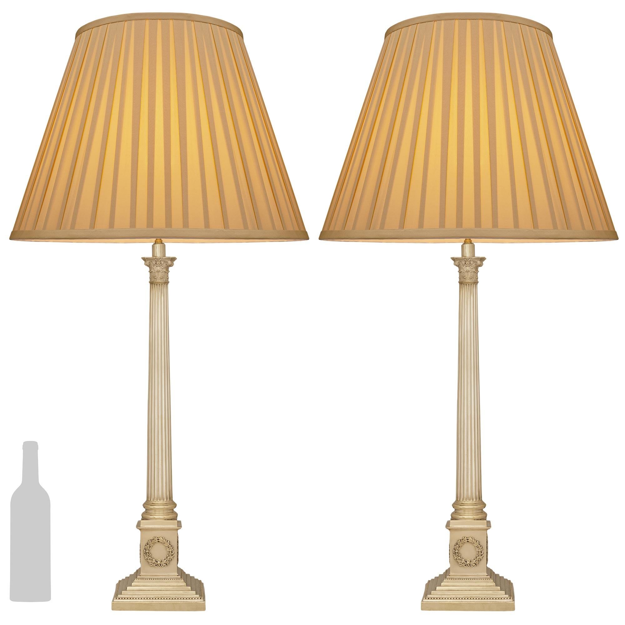 An elegant and most decorative pair of Continental 19th century Neo-Classical st. Silvered Bronze lamps. Each wonderful lamp is raised by a square stepped base with various levels, and a top and bottom beaded trim. The square plinth support above is