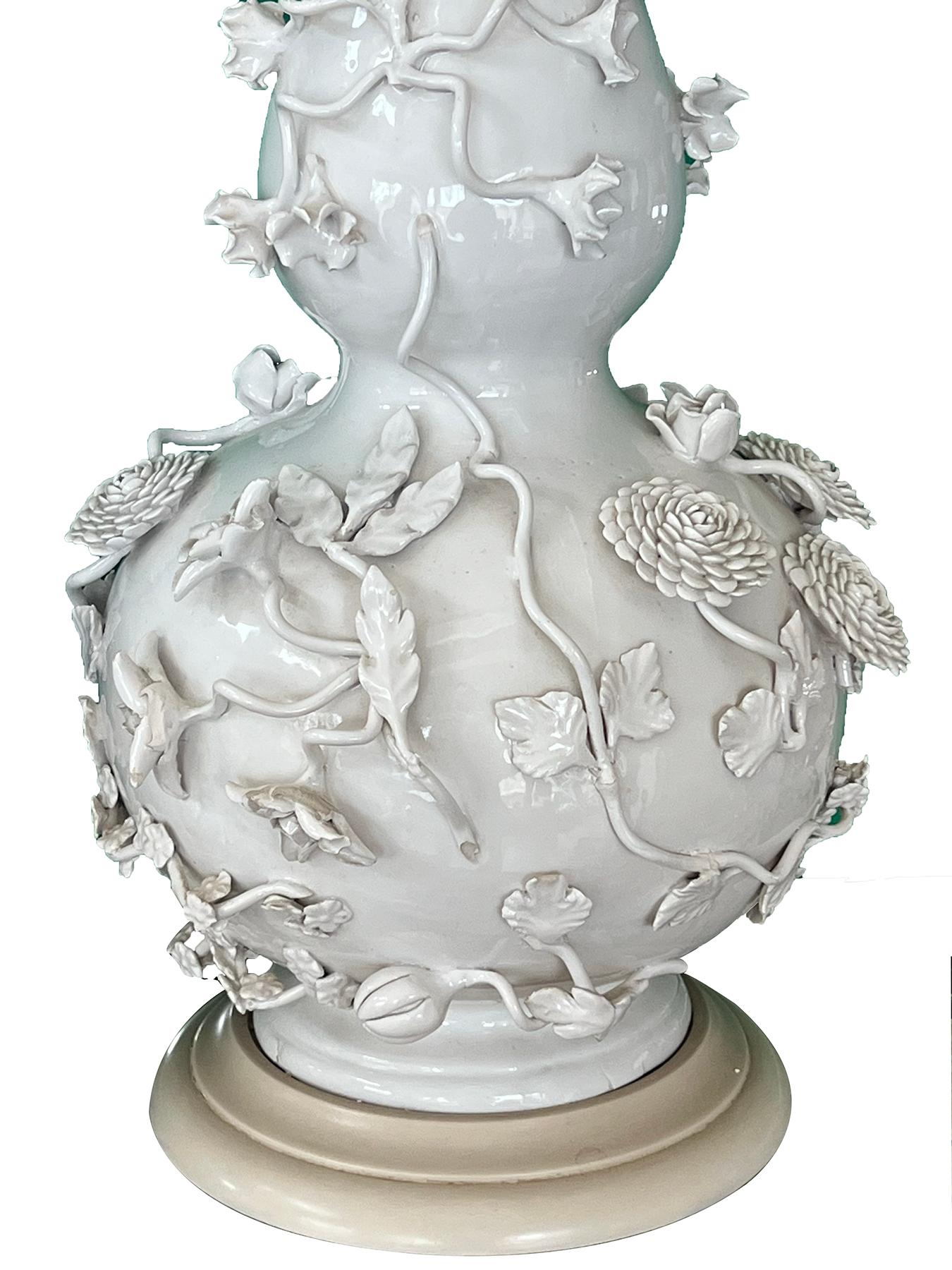 possibly French; each of double-gourd form with applied floral and foliate vines raised on a white painted wooden base