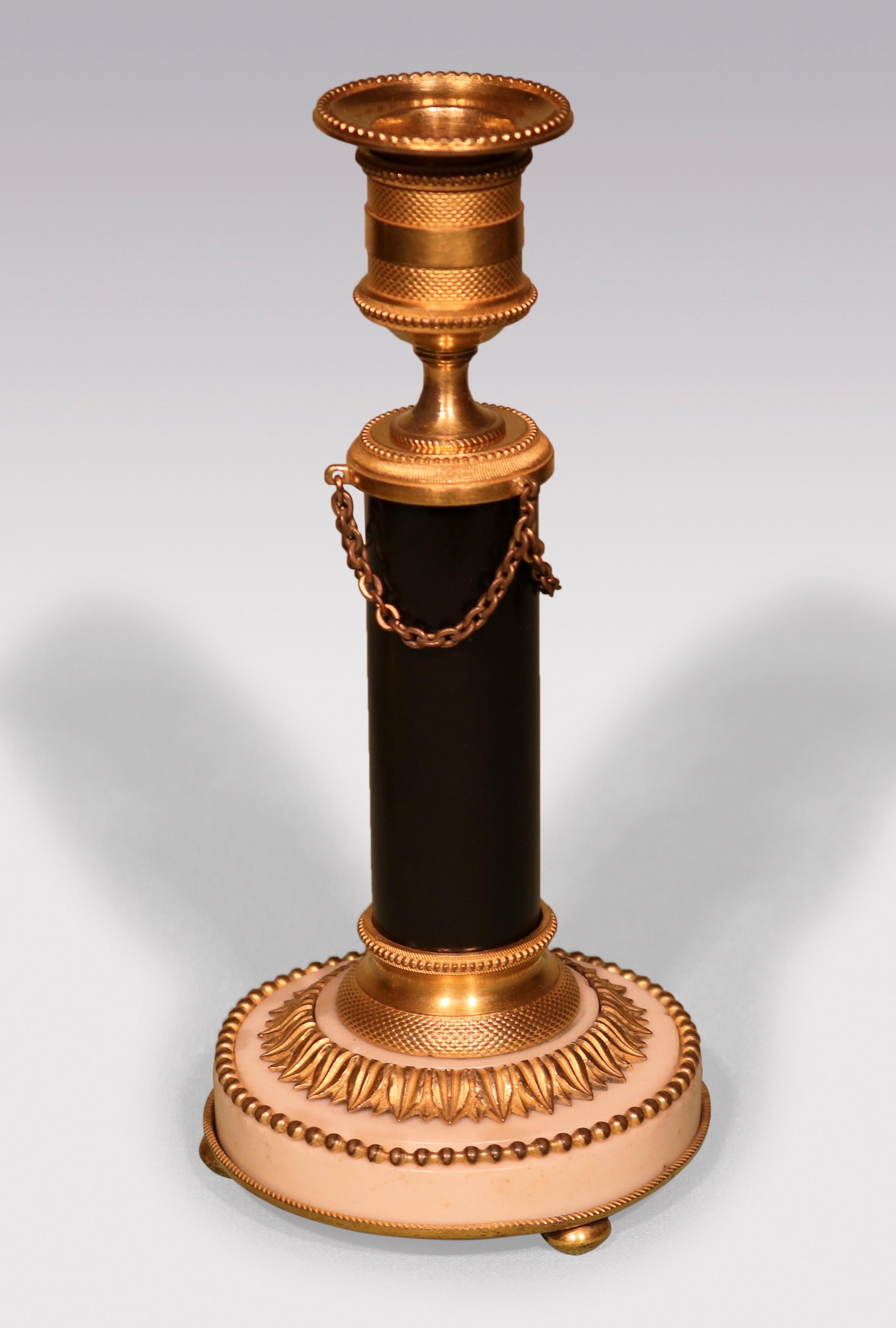 A fine quality pair of Continental bronze & ormolu Candlesticks, having engine turned nozzles raised on black marble stems ending on white marble circular bases.