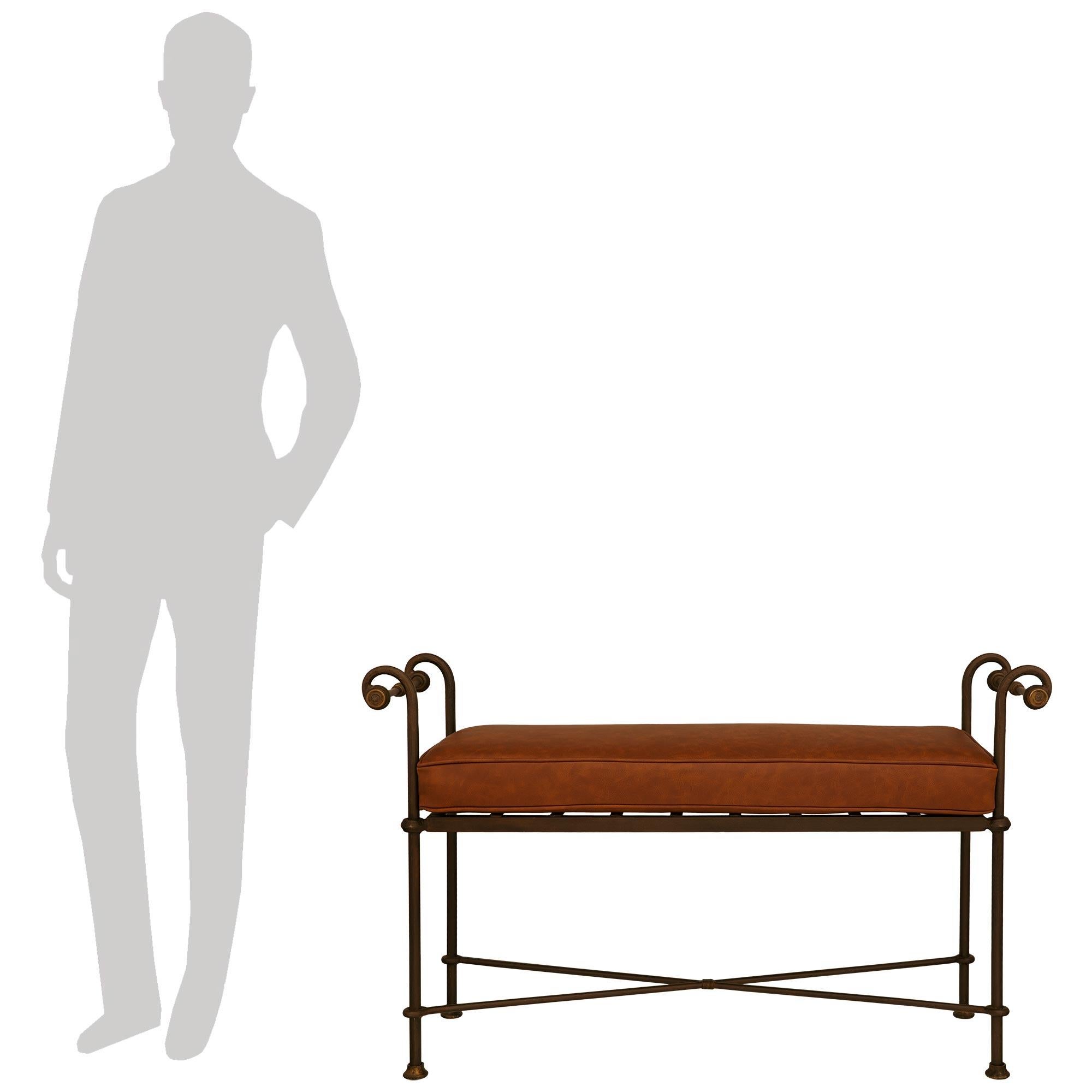 A handsome and most decorative pair of Continental Turn of the Century Wrought Iron benches. This wonderful pair are raised by four straight legs with circular bottom sabots, while joined by an elegant stretcher. The seat displays rounded corners