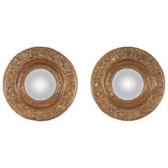 A pair of convex mirrors, brass stylized figures frame. Italy, 19th century.