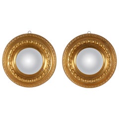 A pair of convex mirrors with embossed brass frames. Italy, late 19th century.