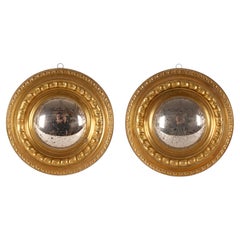 A pair of convex mirrors with smooth, embossed brass frames. Italy, circa 1890.