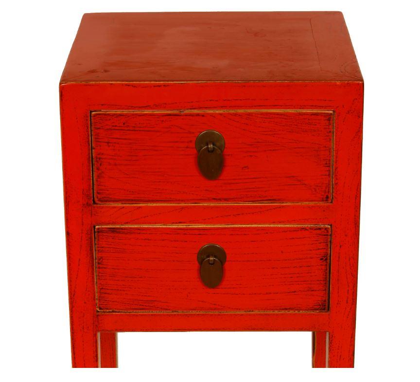 A pair of narrow, coral bedside cabinets in Asian style, with two drawers.