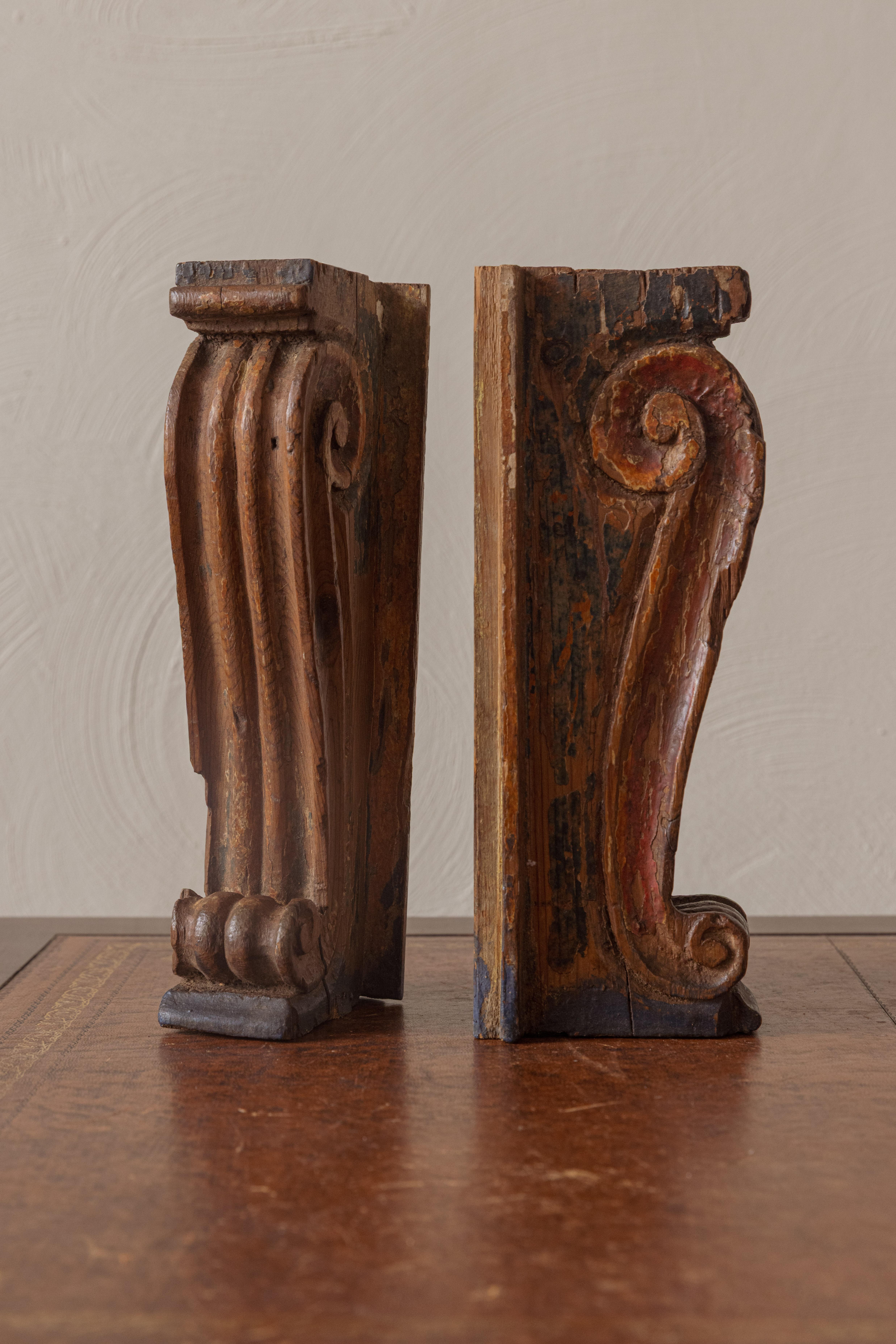 These wooden painted corbels would have been architectural elements, holding up a beam or shelf. They are of Rococo design from the 18th Century. The will work as book ends, shelf supports of decorative objects.