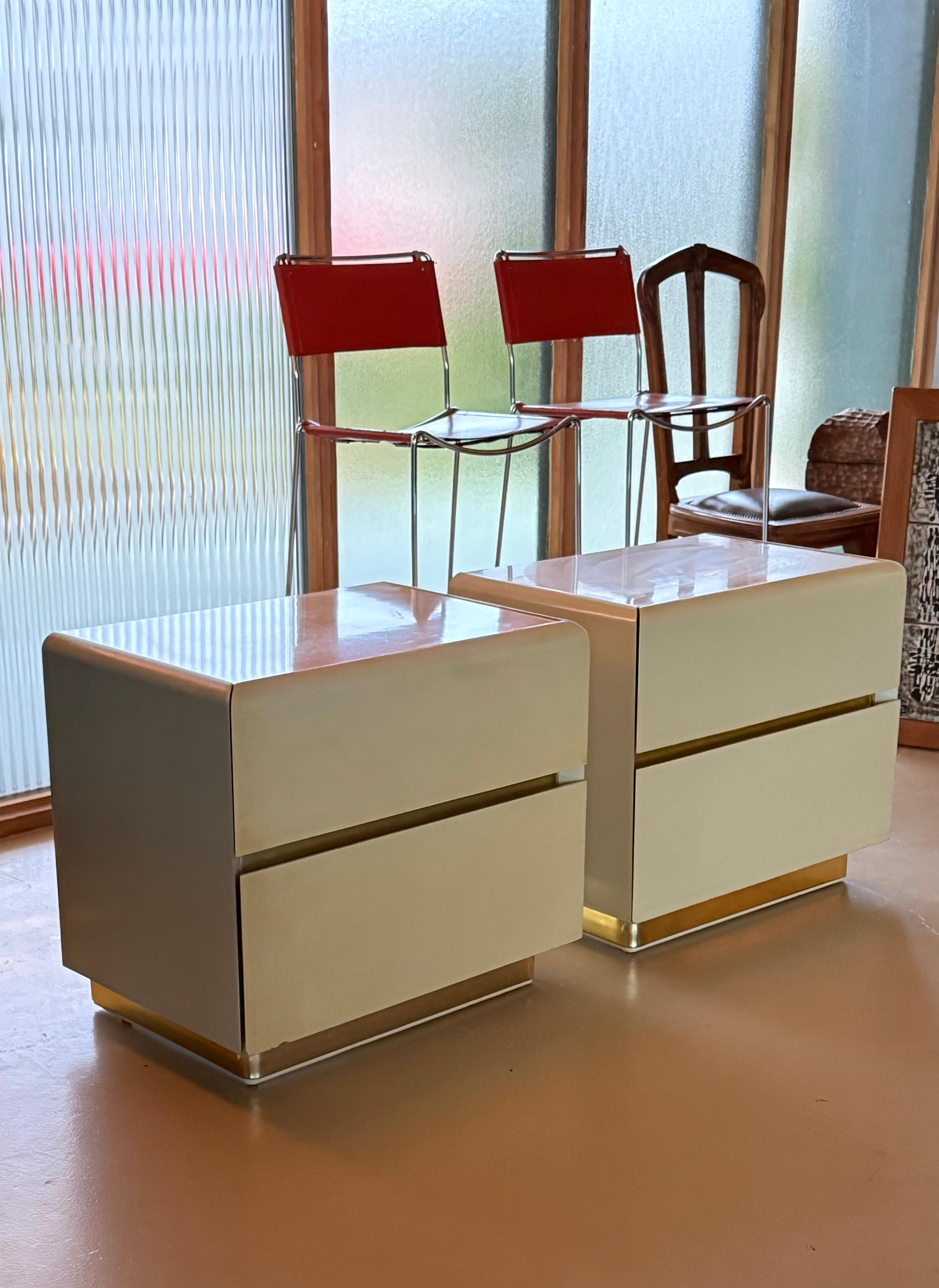 Coppia di comodini in legno massiccio laccato con accenti dorati di Lane Furniture, fine del XX secolo. Questi comodini hanno una spessa tonalità crema e i dettagli dorati brillano alla giusta luce. Ciascuna di esse è dotata di due cassetti